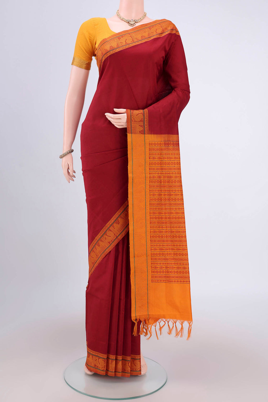 Maroon Blended Poly Cotton Saree with Plain Body and Thread Border.  displayed on a mannequin