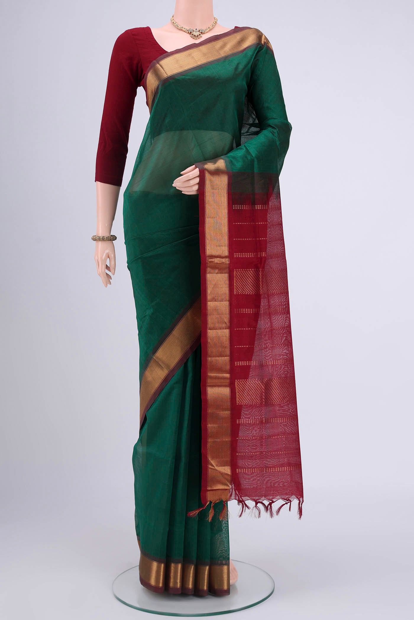 Bottle Green Blended Coimbatore Silk Cotton Saree with Plain Body and Zari Border.  displayed on a mannequin