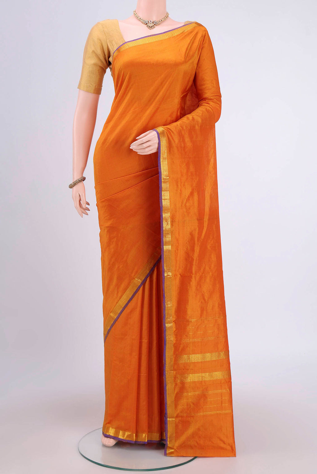 Mustard Kanchipuram Silk Saree with Plain Body and Zari Border.  displayed on a mannequin