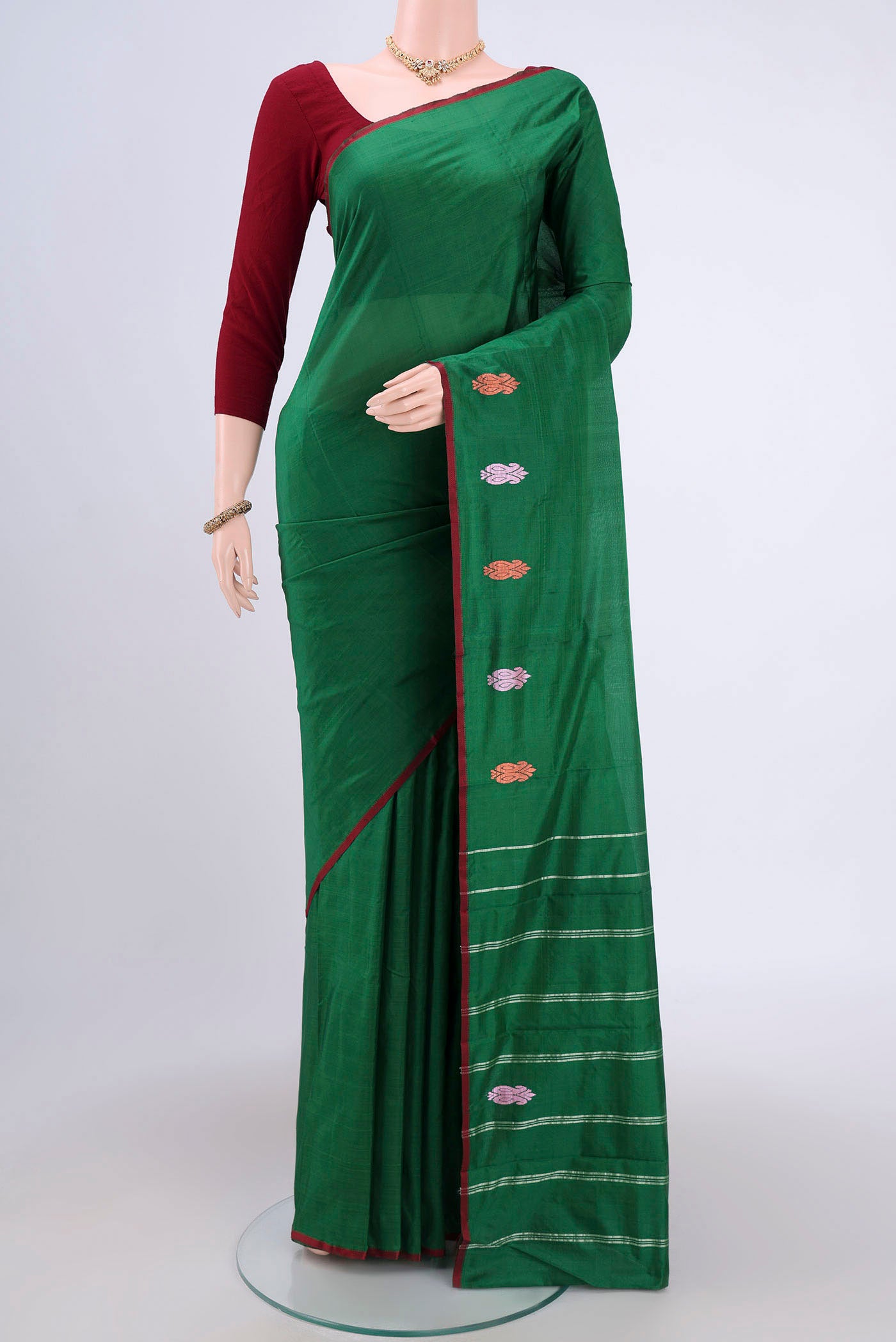 Bottle Green Kanchipuram Saree with Plain Body and Thread Border.  displayed on a mannequin