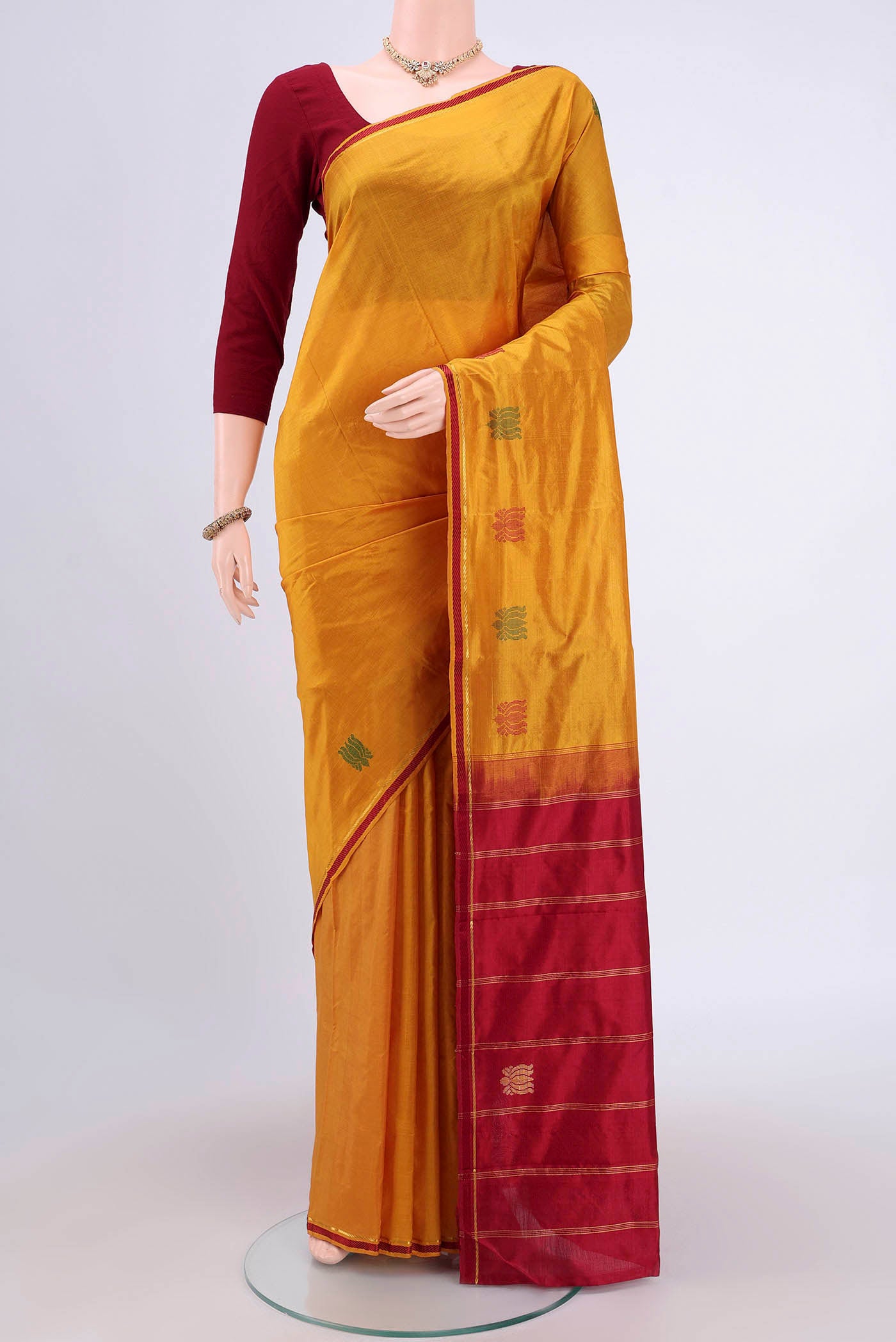 Mustard Kanchipuram Saree with Plain Body and Zari And Thread Border.  displayed on a mannequin