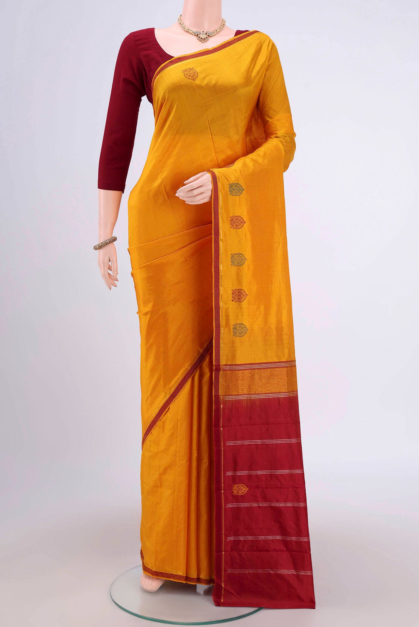 Mustard Kanchipuram Saree with Plain Body and Zari And Thread Border.  displayed on a mannequin