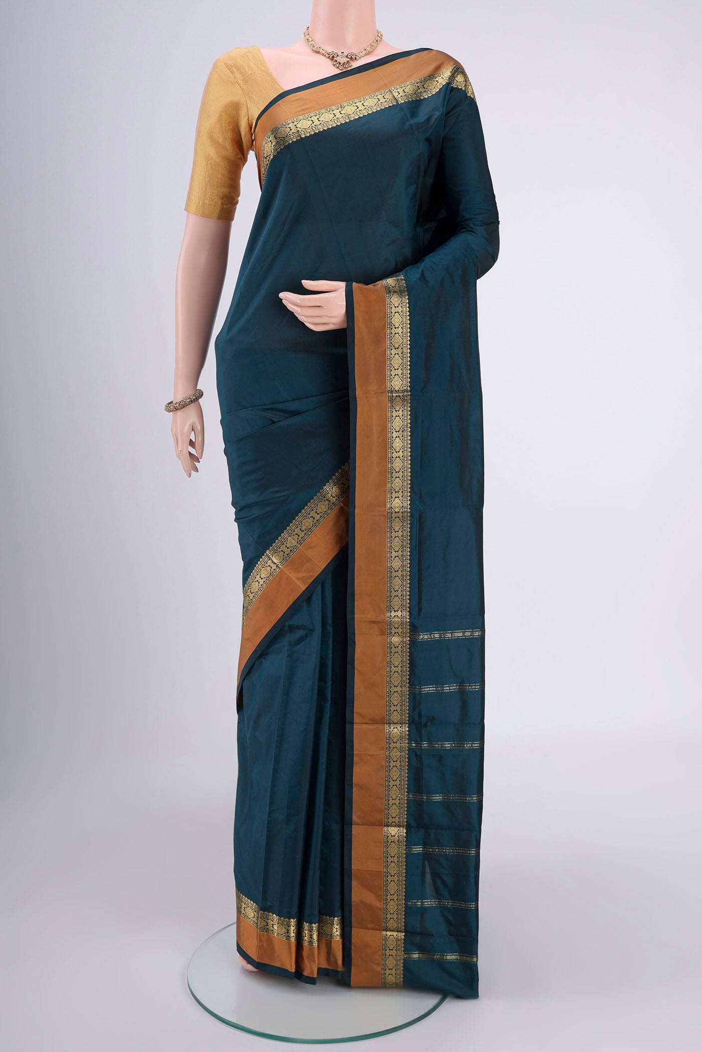 Bottle Green Blended Bangalore Silk Saree with Zari Butta on the body and Zari Border.  displayed on a mannequin