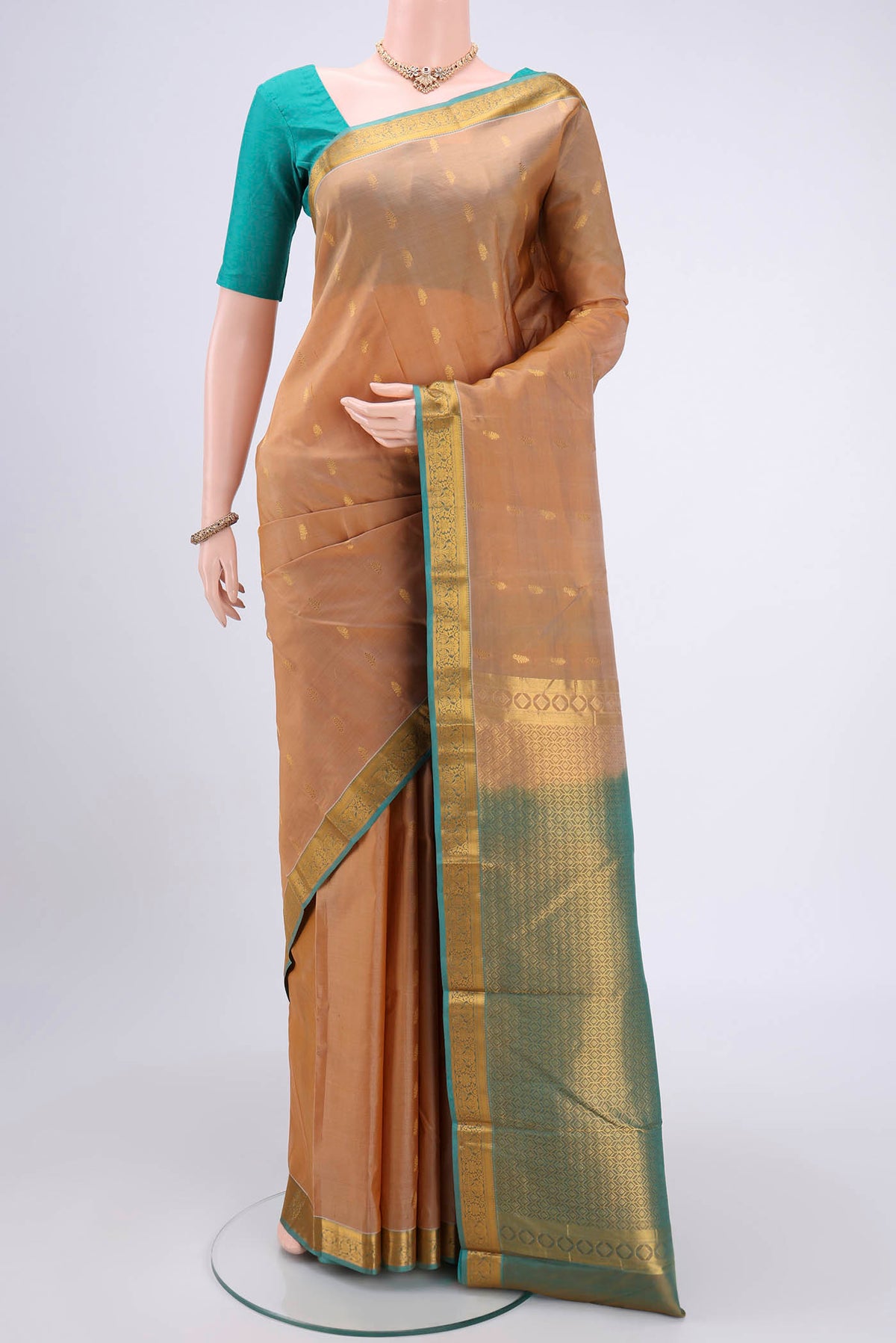 Beige Kanjivaram Silk Saree with Zari Butta on the body and Zari Border.  displayed on a mannequin