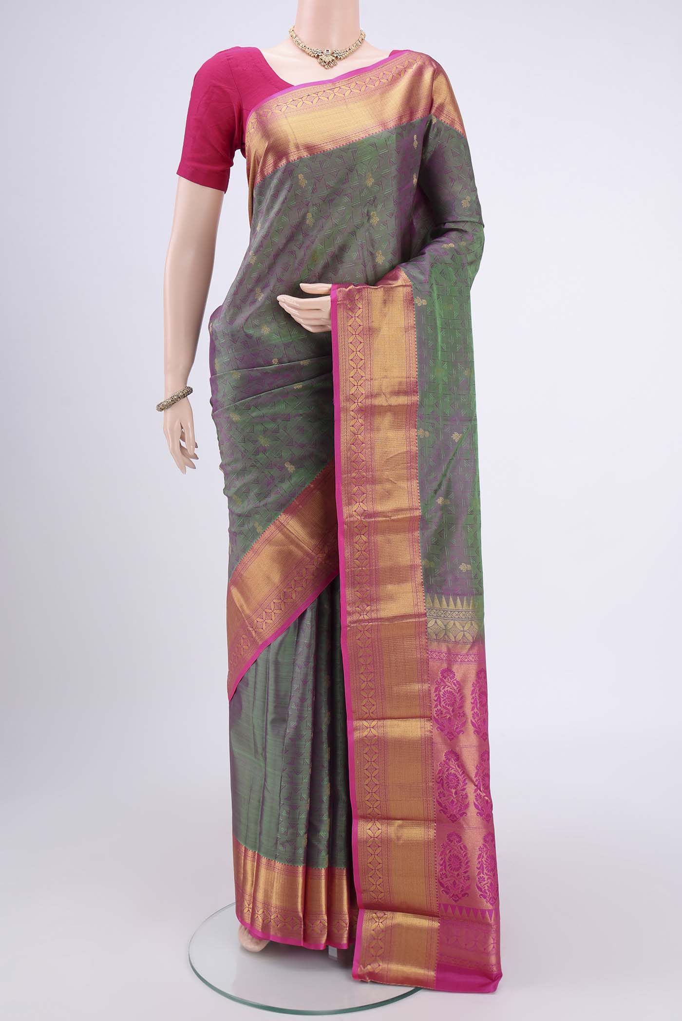 Bottle Green Kanchipuram Silk Saree with Zari Butta on the body and Zari Border.  displayed on a mannequin