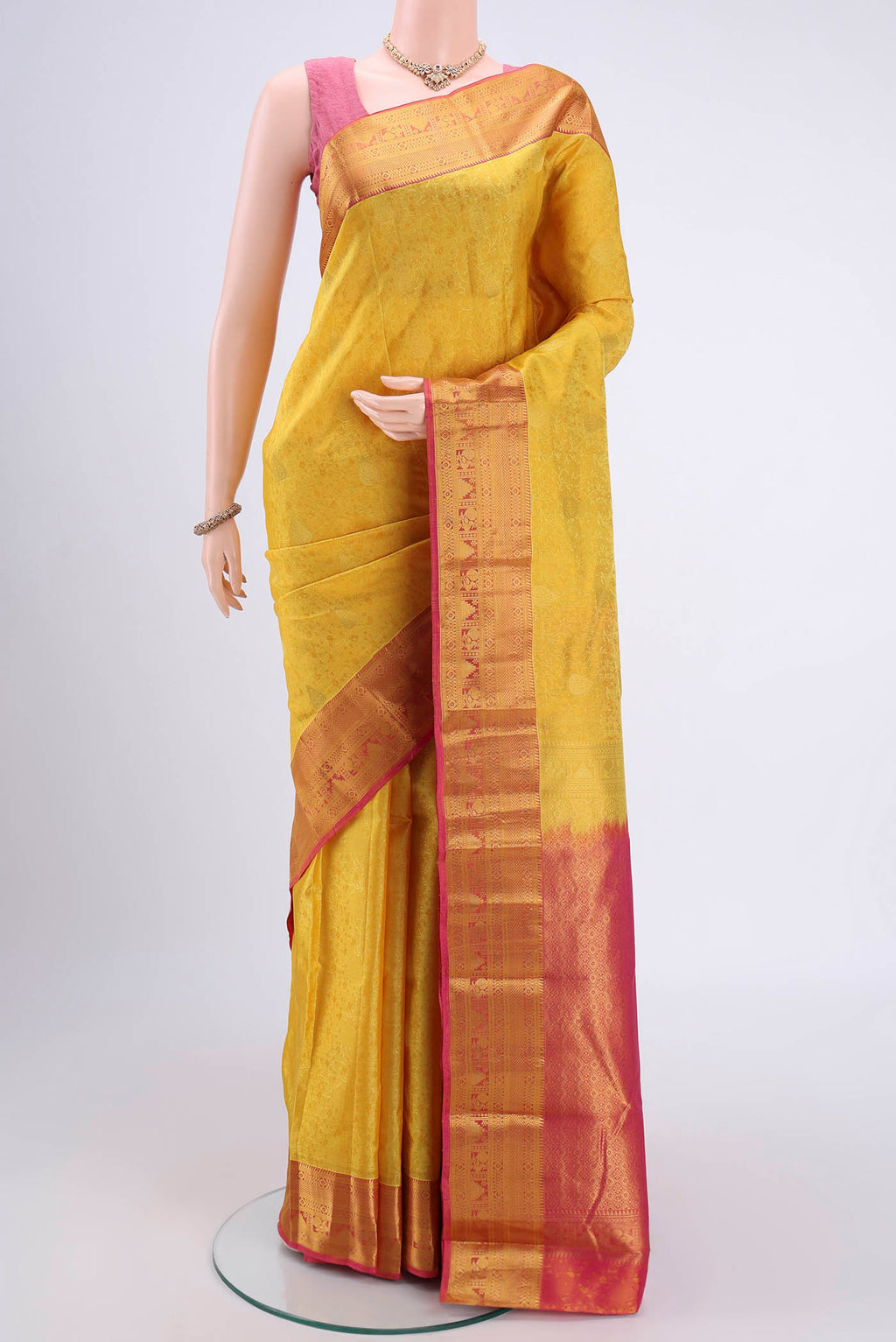 Yellow Kanchipuram Silk Saree with Zari Butta on the body and Zari Border.  displayed on a mannequin