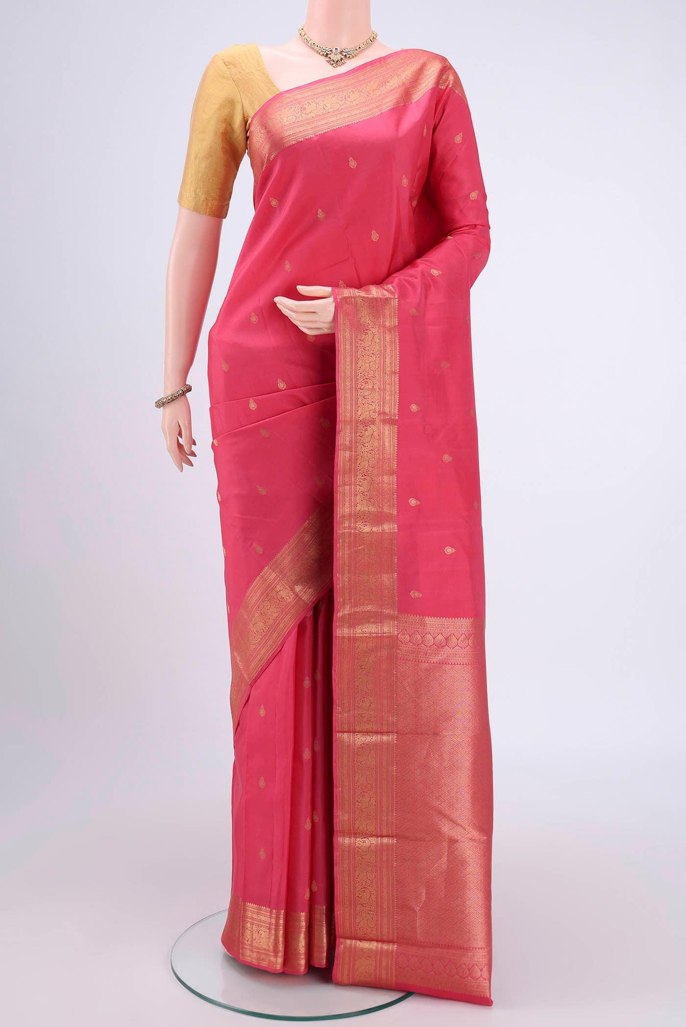 Pink Kanchipuram Silk Saree with Zari Butta on the body and Zari Border.  displayed on a mannequin