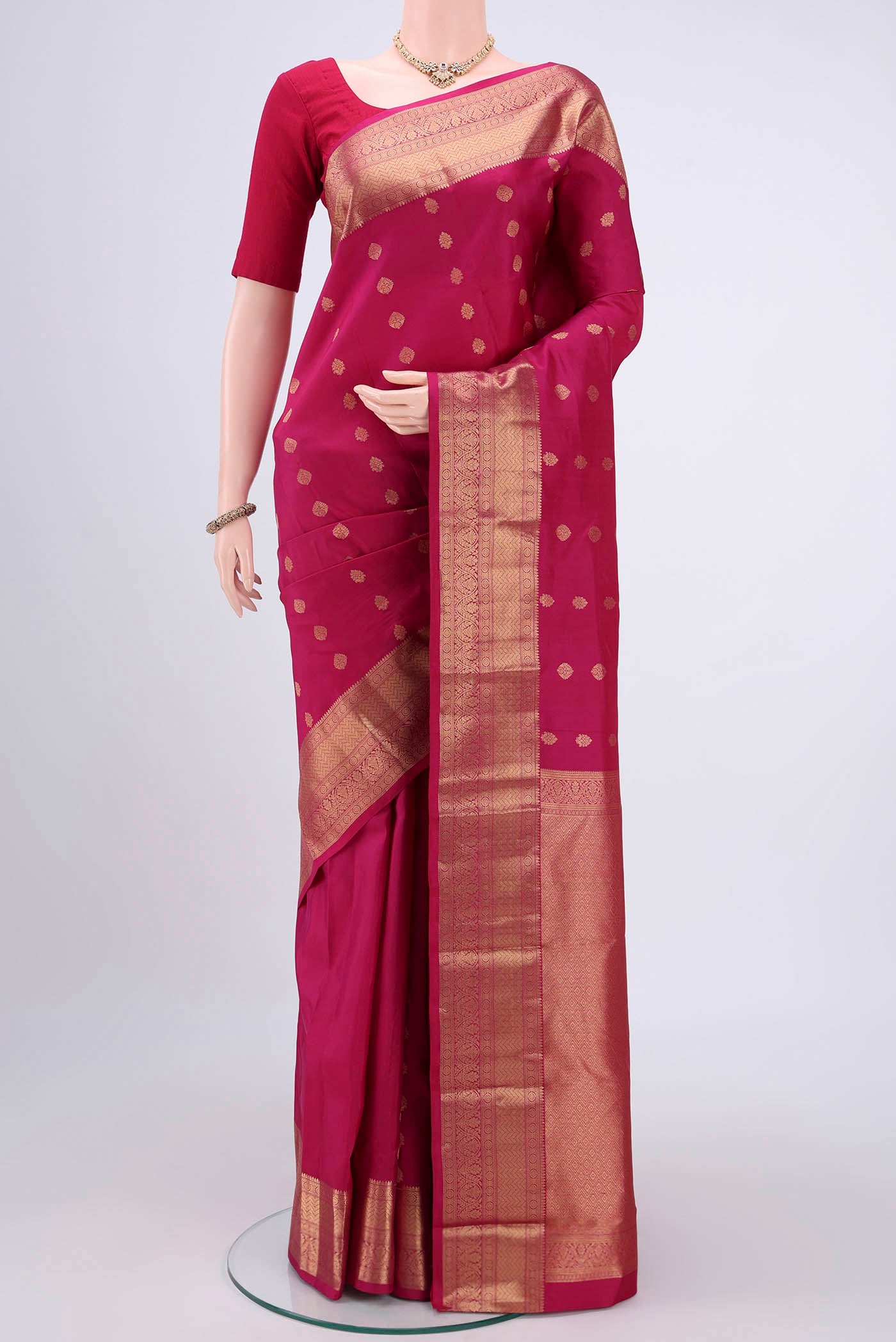 Pink Kanchipuram Silk Saree with Zari Butta on the body and Zari Border.  displayed on a mannequin