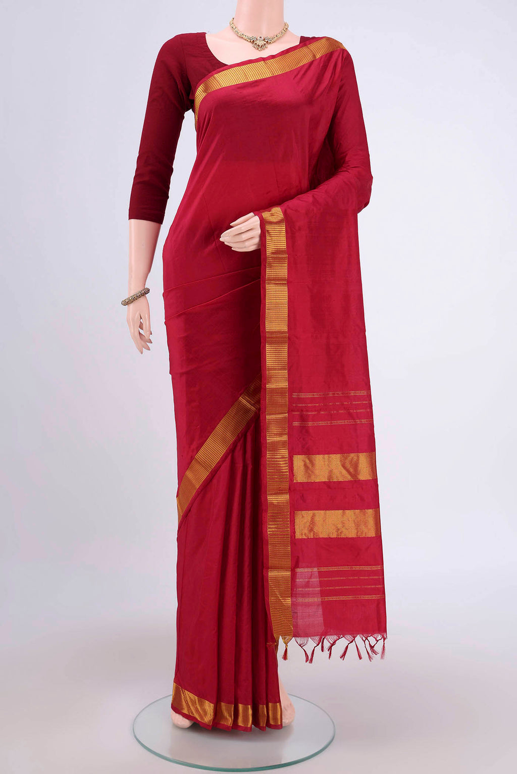 Maroon Kanjivaram Silk Saree with Plain Body and Zari Border.  displayed on a mannequin