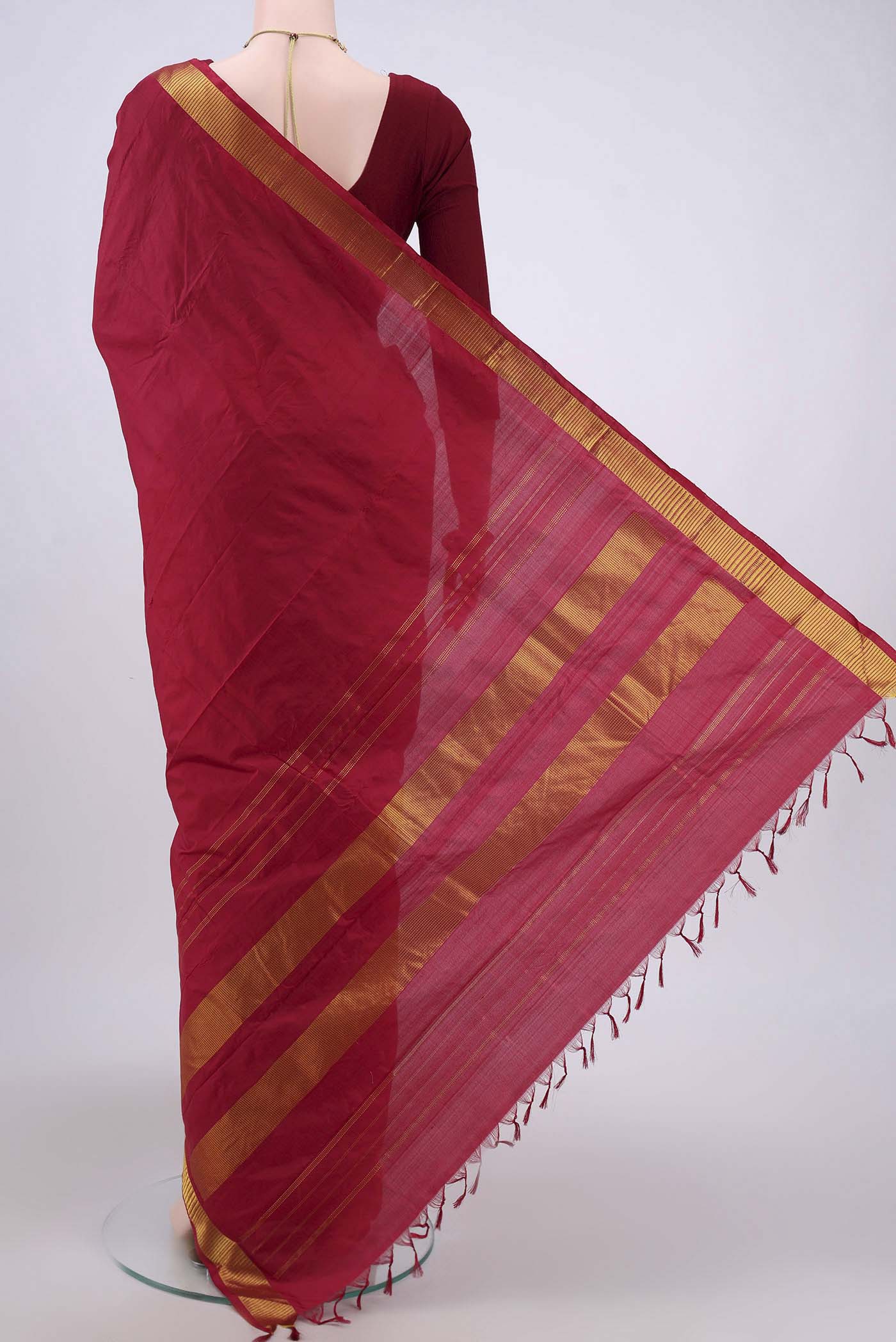 Flat view of Maroon Kanjivaram Silk Saree with Plain Body and Zari Border. 