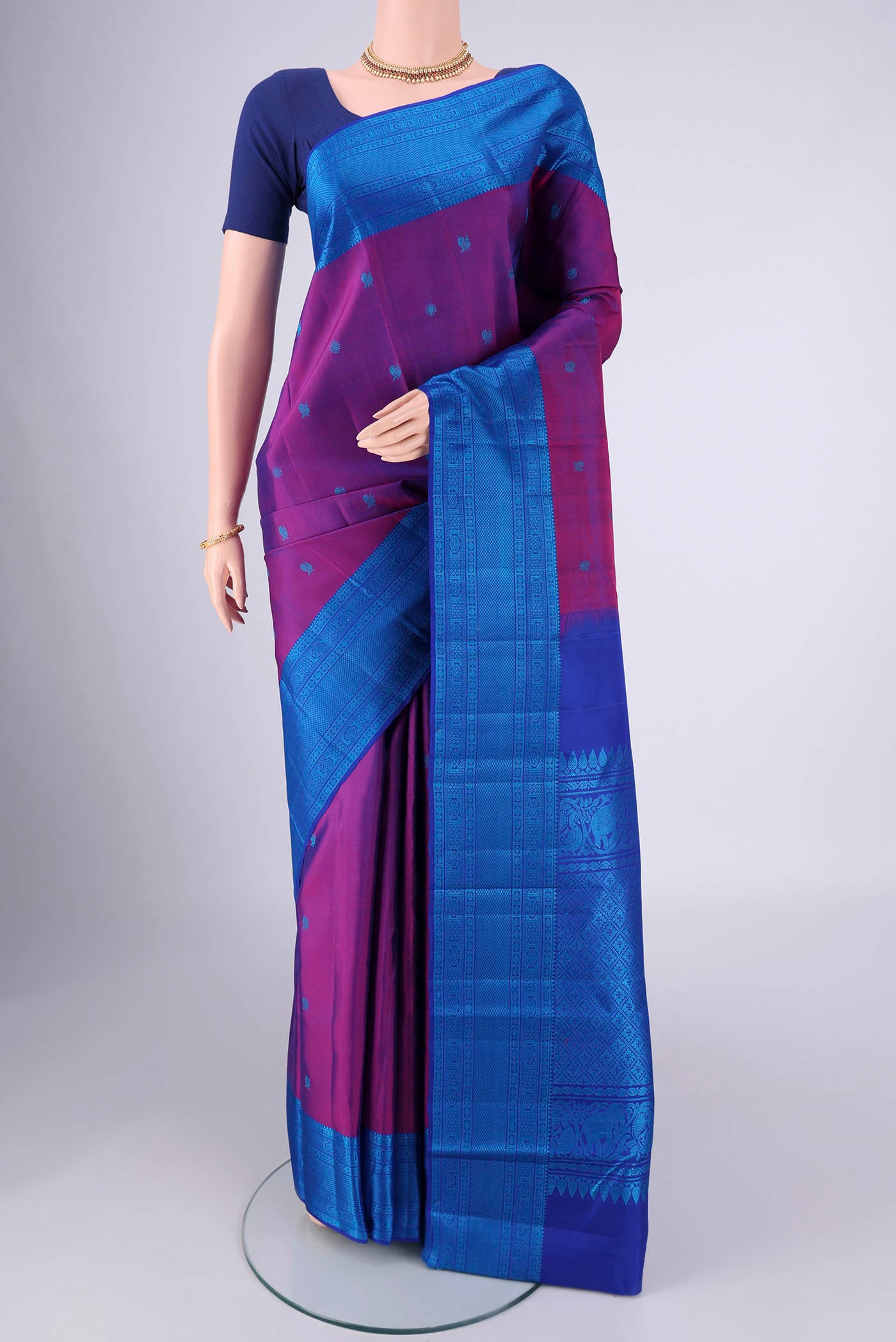 Magenta Kanchipuram Silk Saree with Thread Butta on the body and Thread Border.  displayed on a mannequin