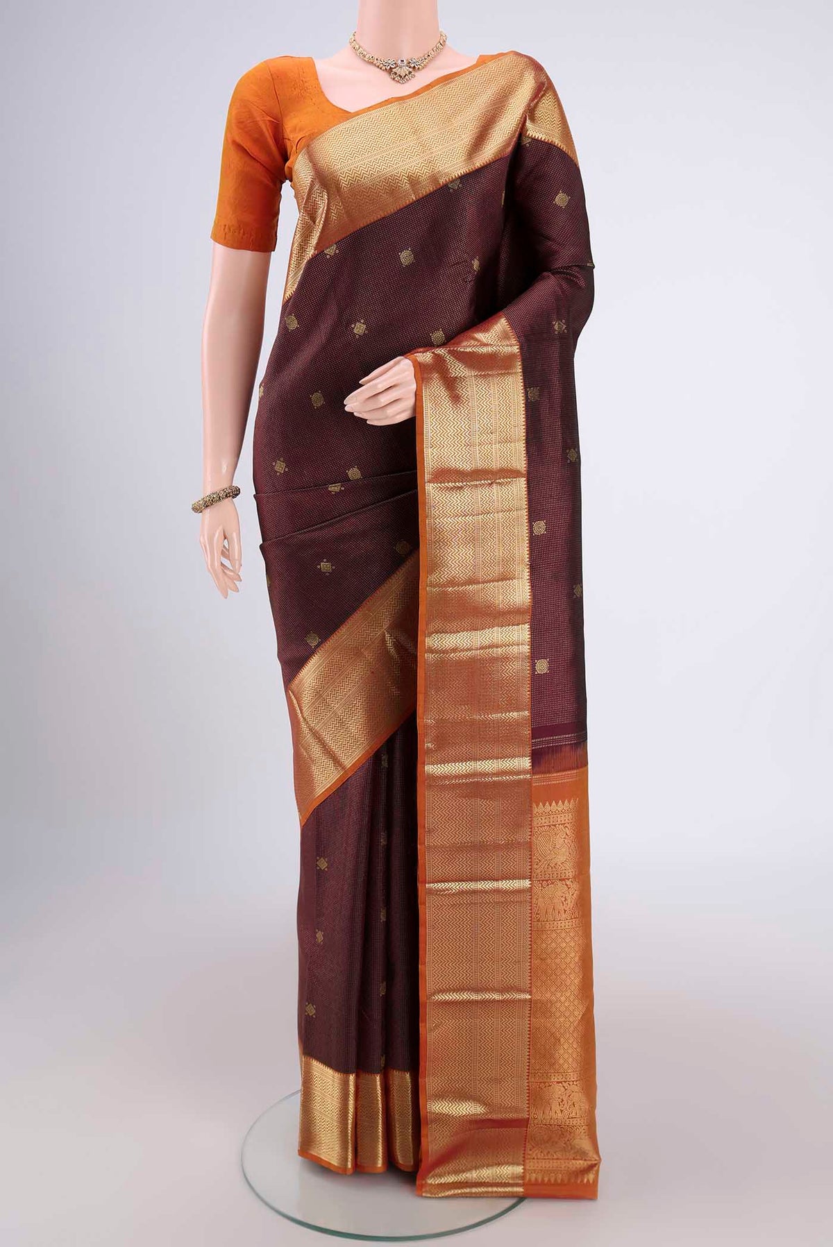 Maroon Kanjivaram Silk Saree with Zari Brocade on the body and Zari Border.  displayed on a mannequin
