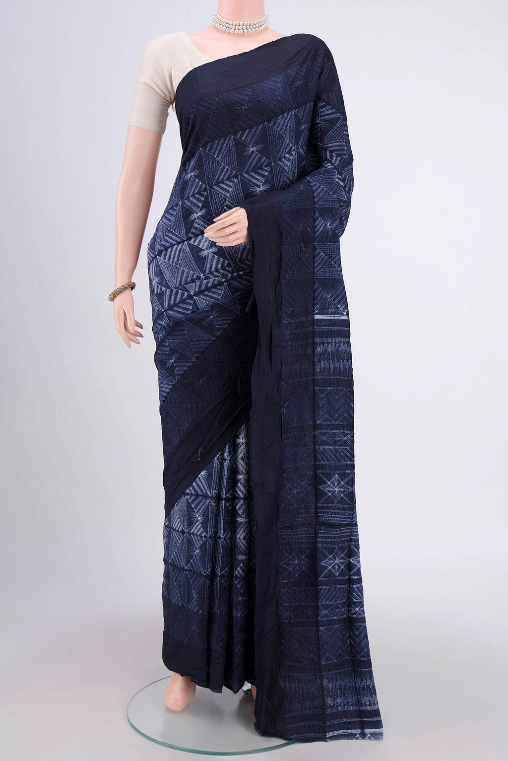 Navy Blue Printed Silk Saree with Printed design on the body and Plain Border.  displayed on a mannequin