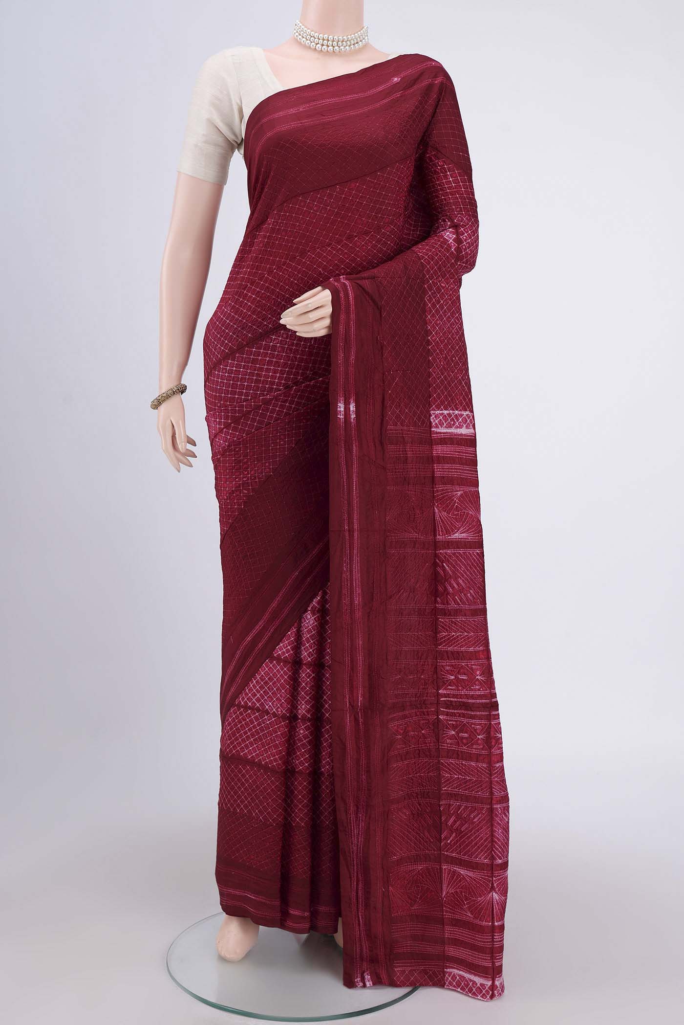Maroon Printed Silk Saree with Printed design on the body and Plain Border.  displayed on a mannequin