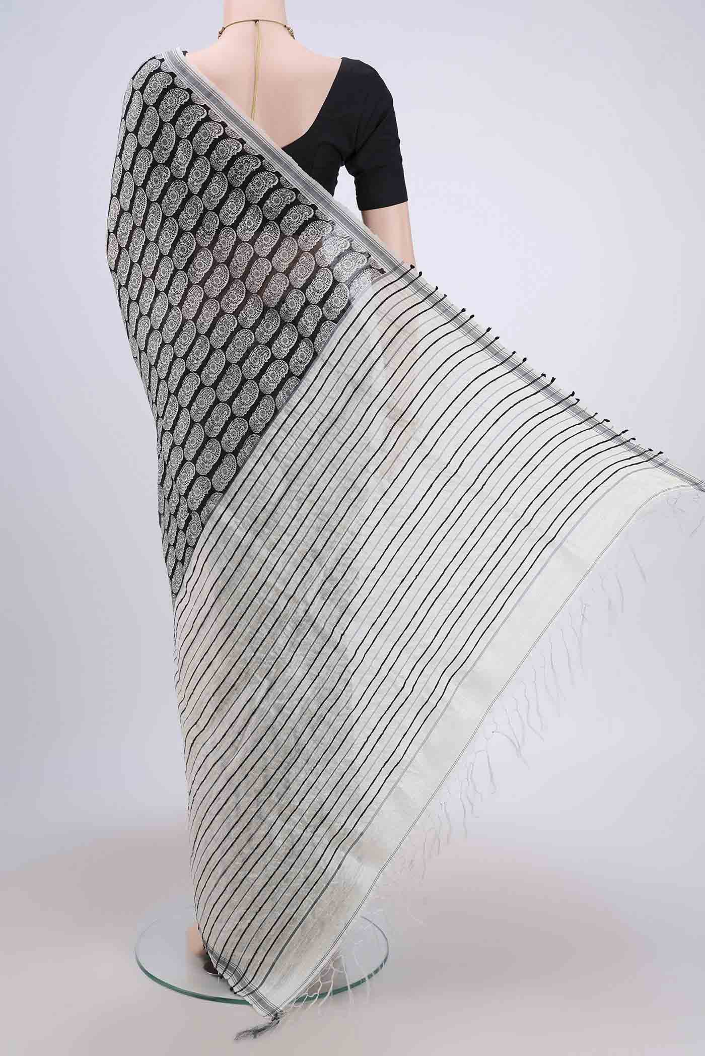 Flat view of Black Dual Tone Tussar Silk Saree with Printed design on the body and Zari Border. 