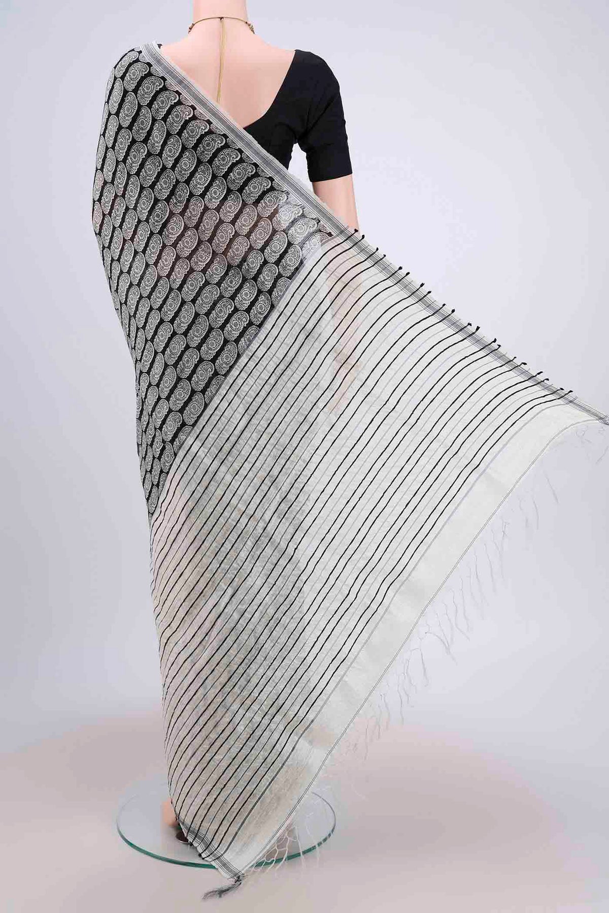Flat view of Black Dual Tone Tussar Silk Saree with Printed design on the body and Zari Border. 