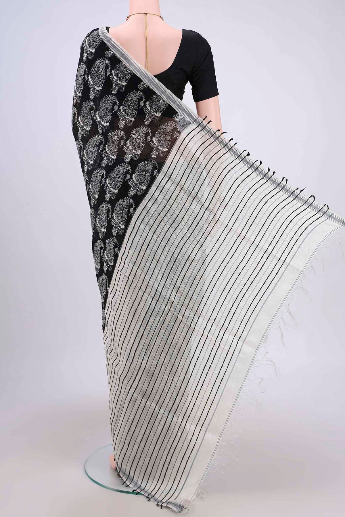 Flat view of Black Dual Tone Tussar Silk Saree with Printed design on the body and Zari Border. 