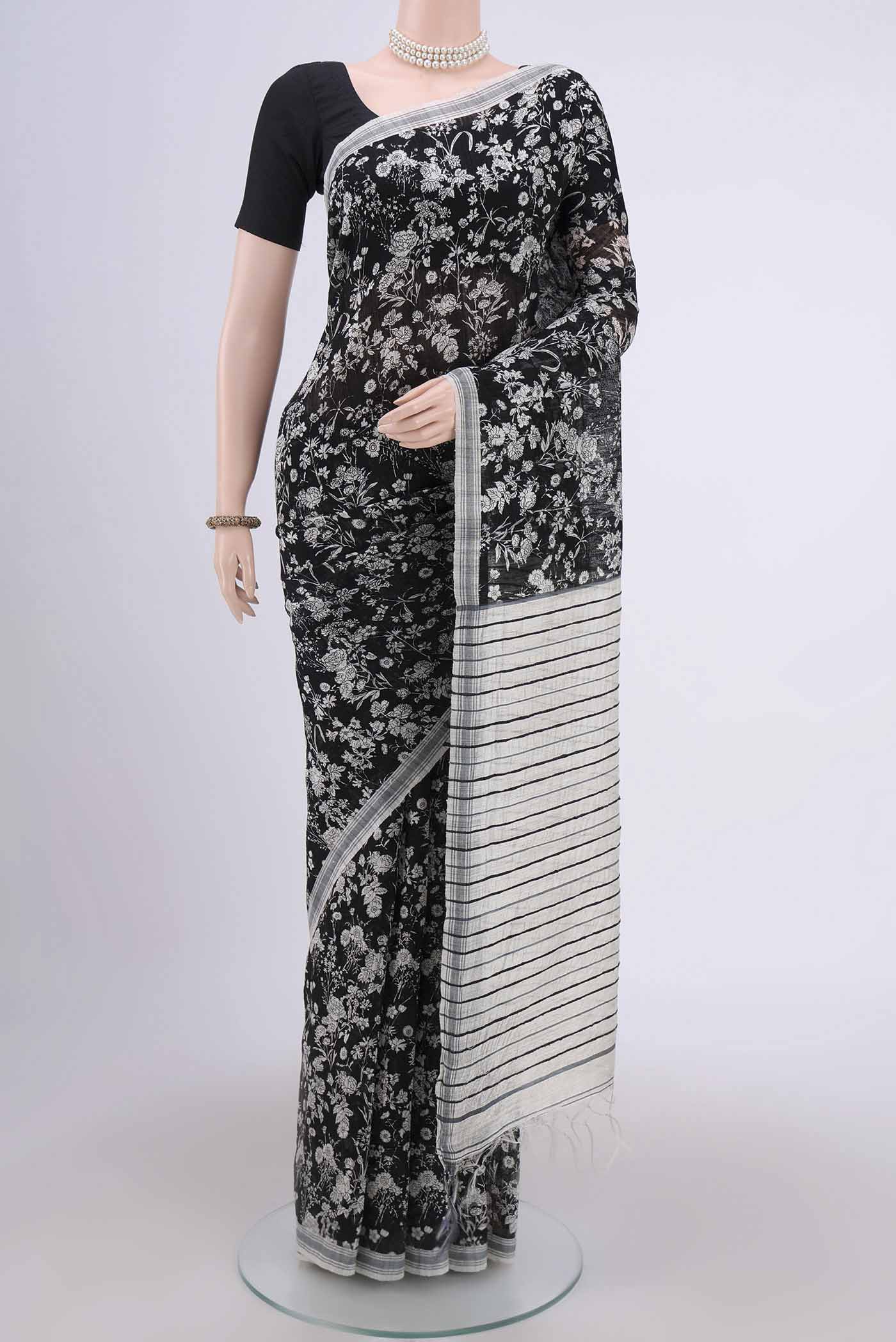 Black Dual Tone Tussar Silk Saree with Printed design on the body and Zari Border.  displayed on a mannequin