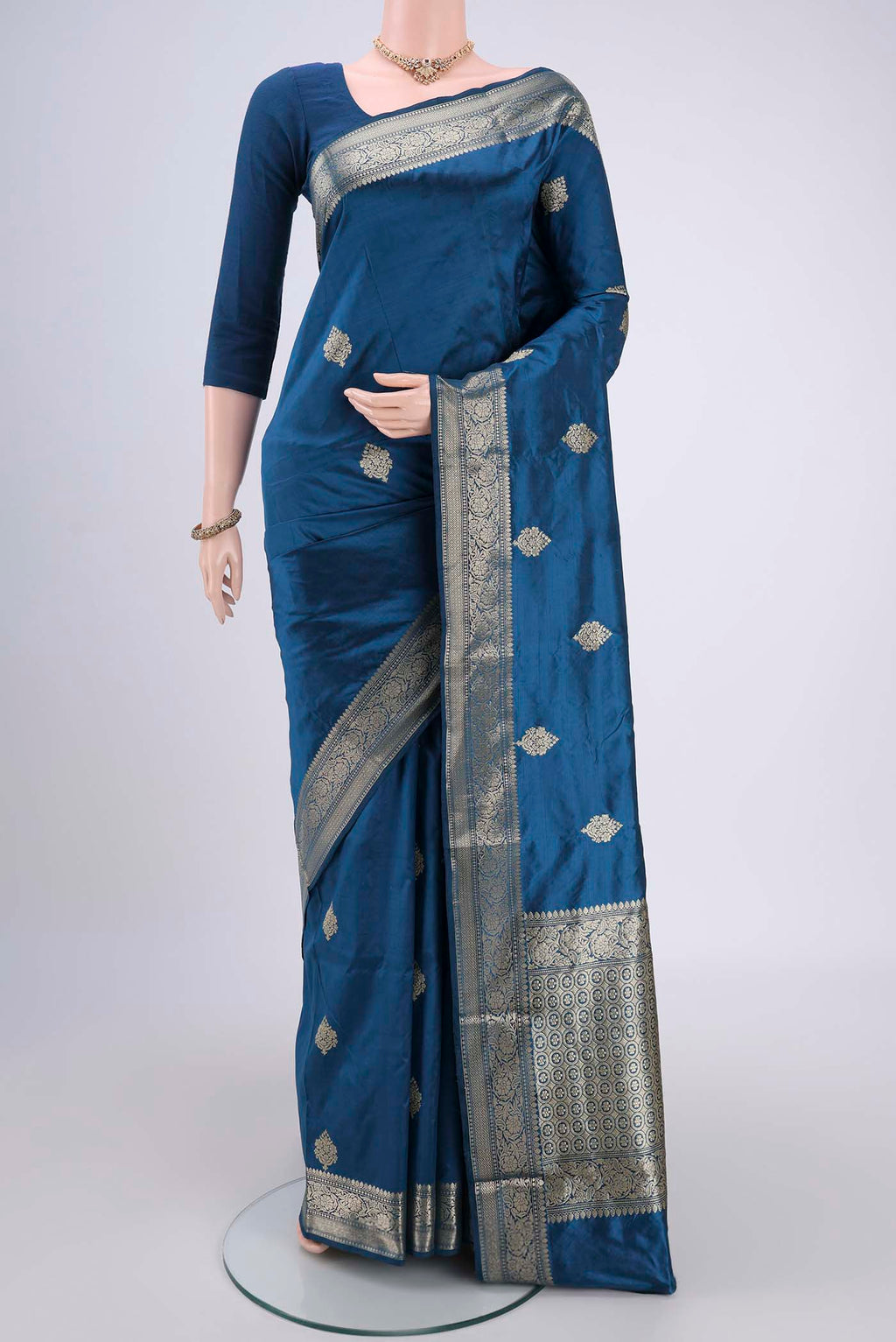Turquoise Banarasi Katan Silk Saree with Zari Butta on the body and Zari Border.  displayed on a mannequin