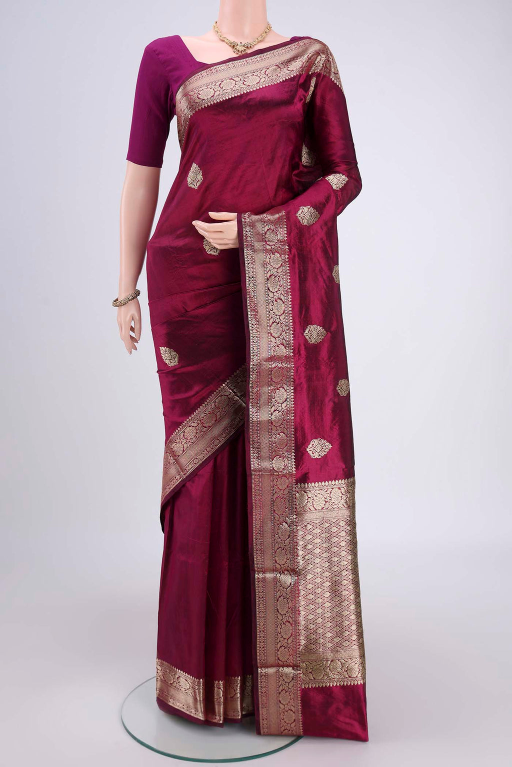 Magenta Banarasi Katan Silk Saree with Zari Butta on the body and Zari Border.  displayed on a mannequin