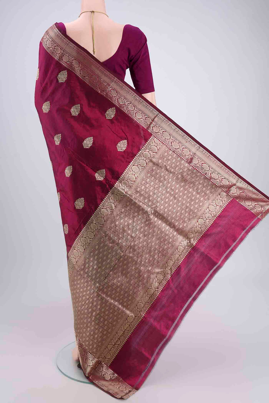 Flat view of Magenta Banarasi Katan Silk Saree with Zari Butta on the body and Zari Border. 