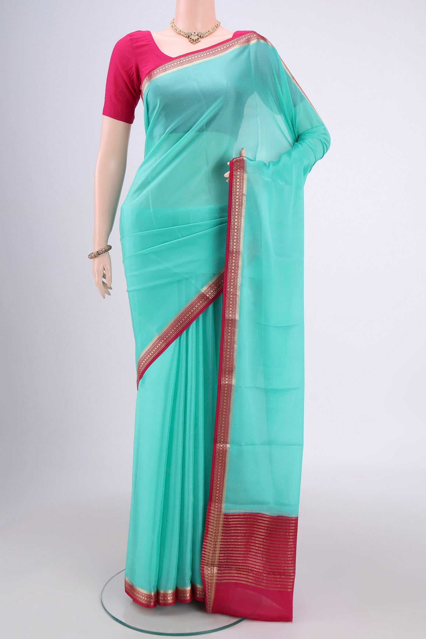 Mint Green Mysore Crepe Saree with Plain Body and Zari Border.  displayed on a mannequin