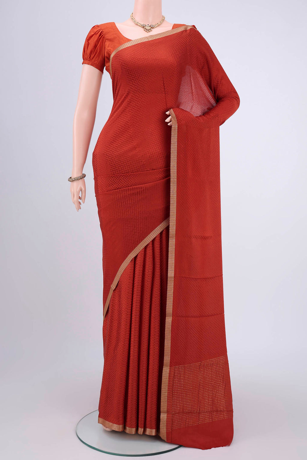 Rust Mysore Crepe Saree with Jacquard design on the body and Zari Border.  displayed on a mannequin