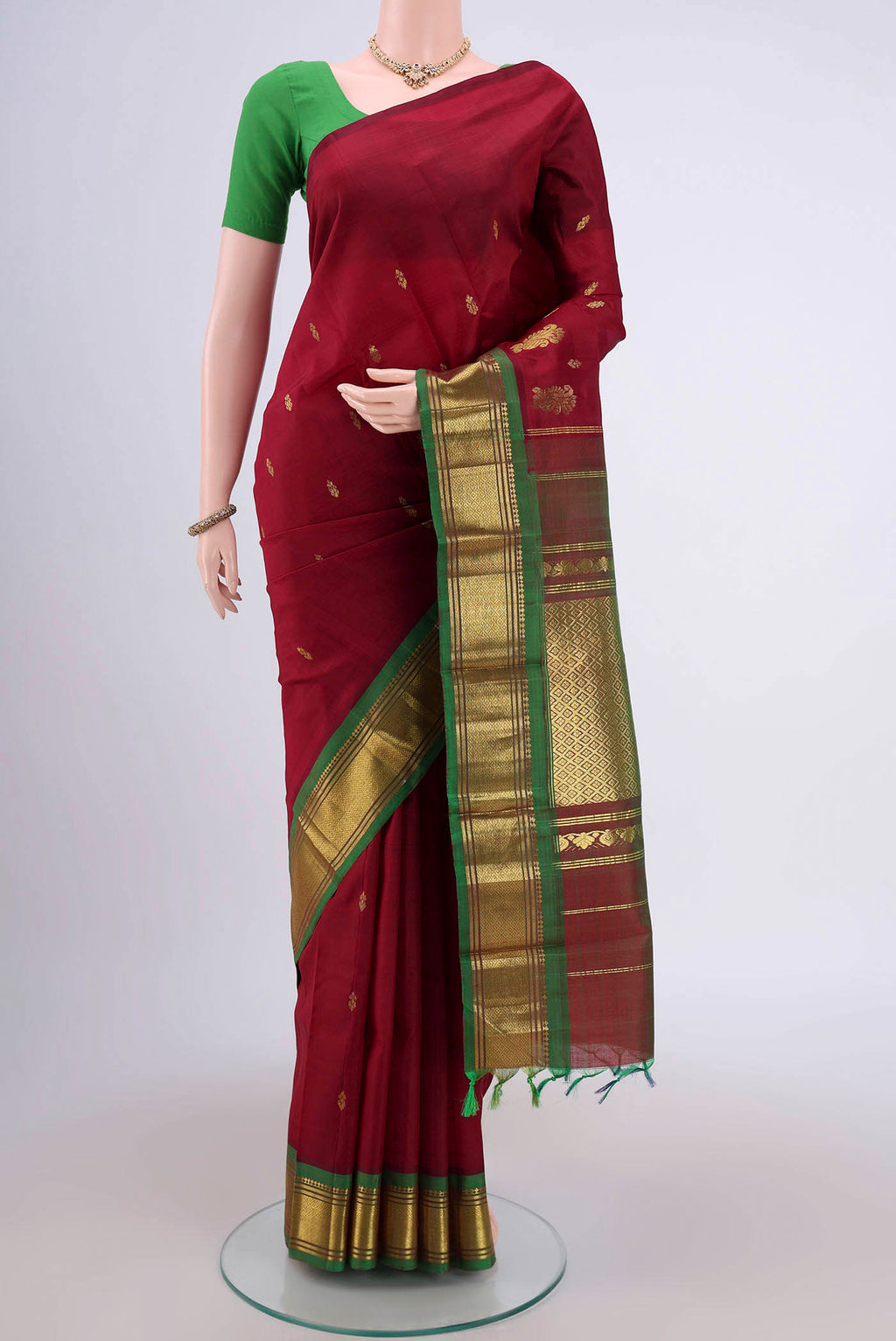 Maroon Kanjivaram Silk Saree with Zari Butta on the body and One Side Border.  displayed on a mannequin