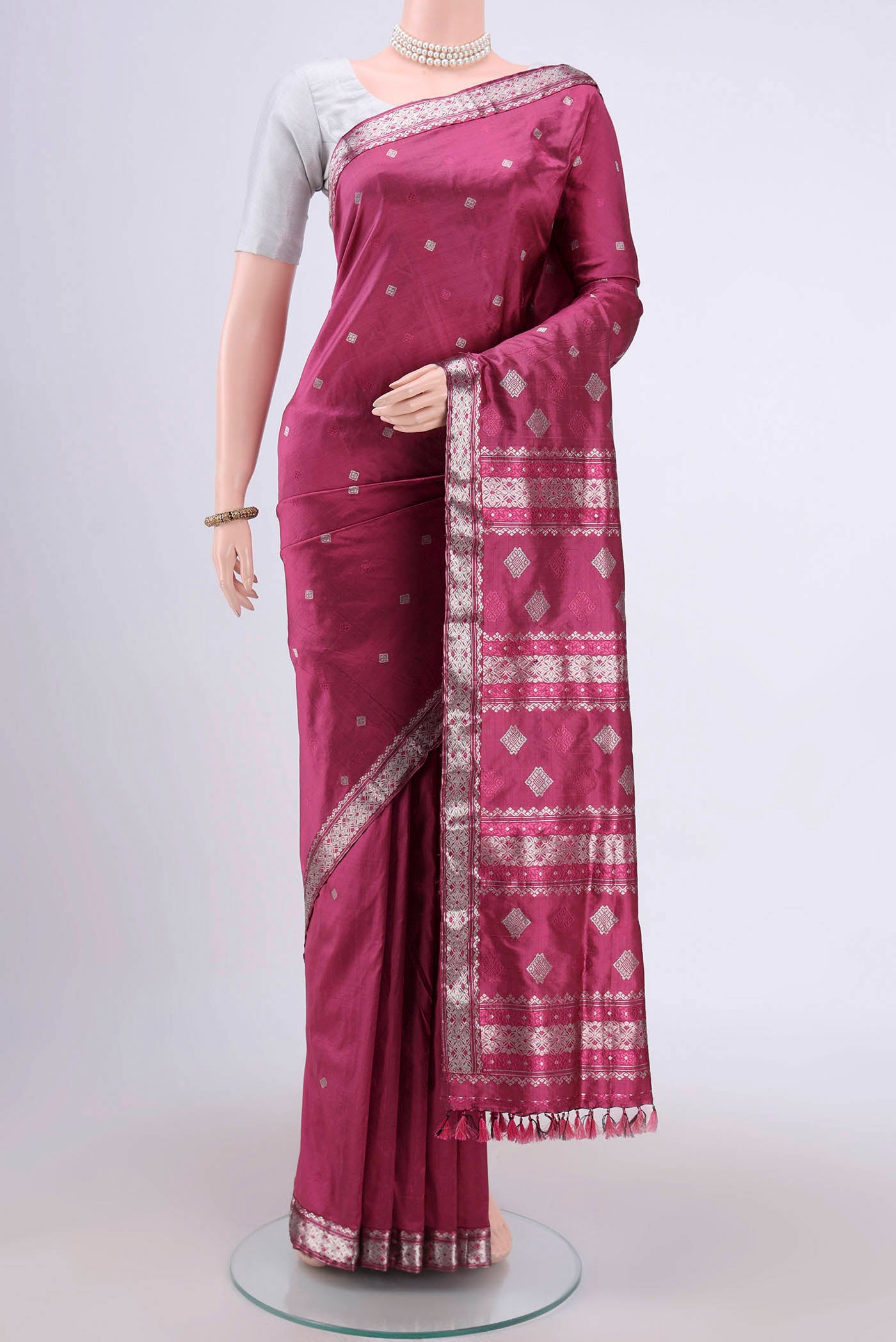Pink Assam Silk Saree with Zari Butta on the body and Zari Border.  displayed on a mannequin