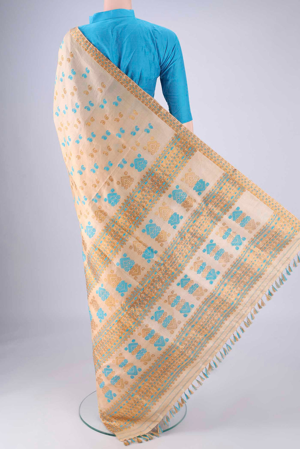 Flat view of Beige Assam Silk Saree with Thread Butta on the body and Thread Border. 