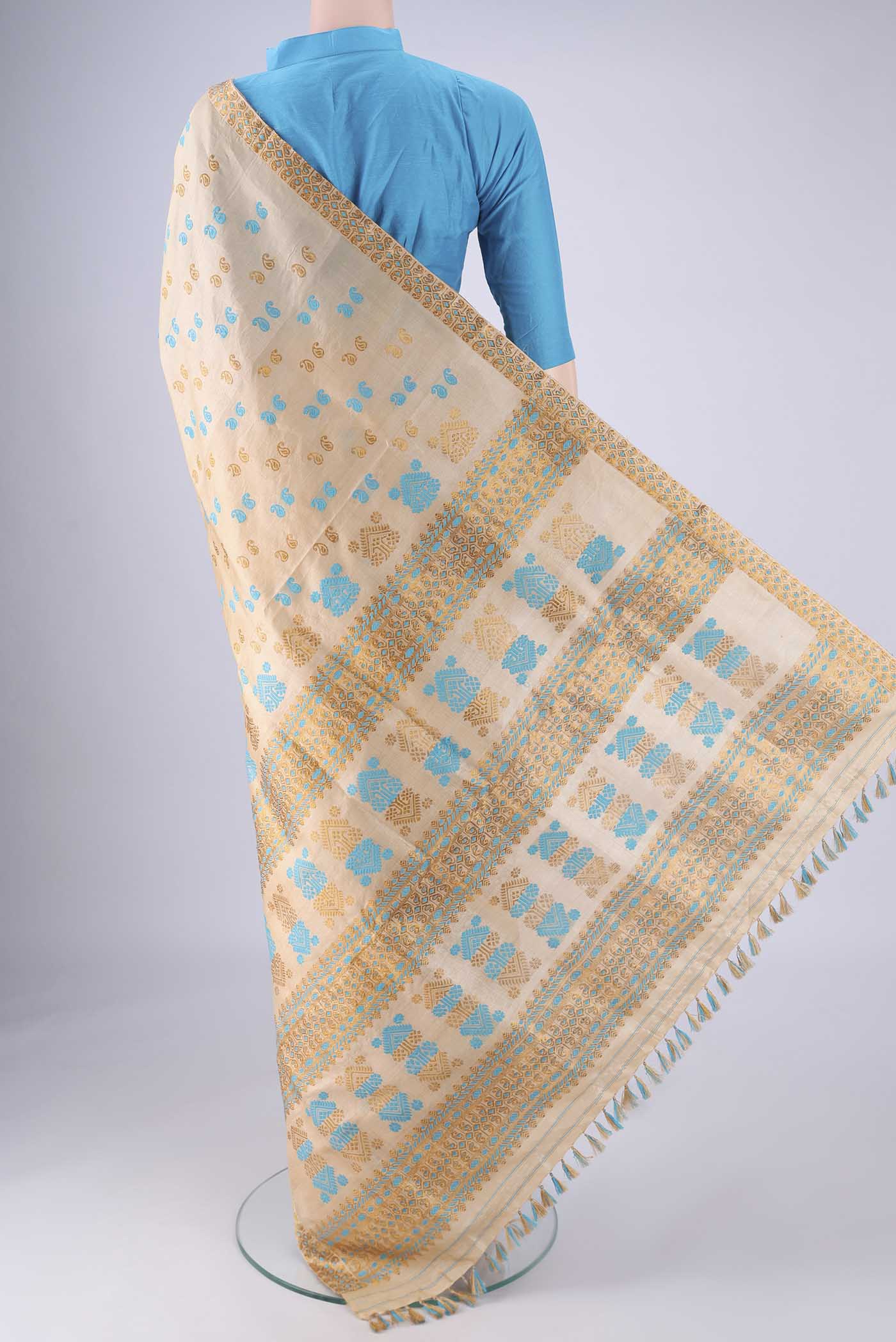 Flat view of Beige Assam Silk Saree with Thread Butta on the body and Thread Border. 