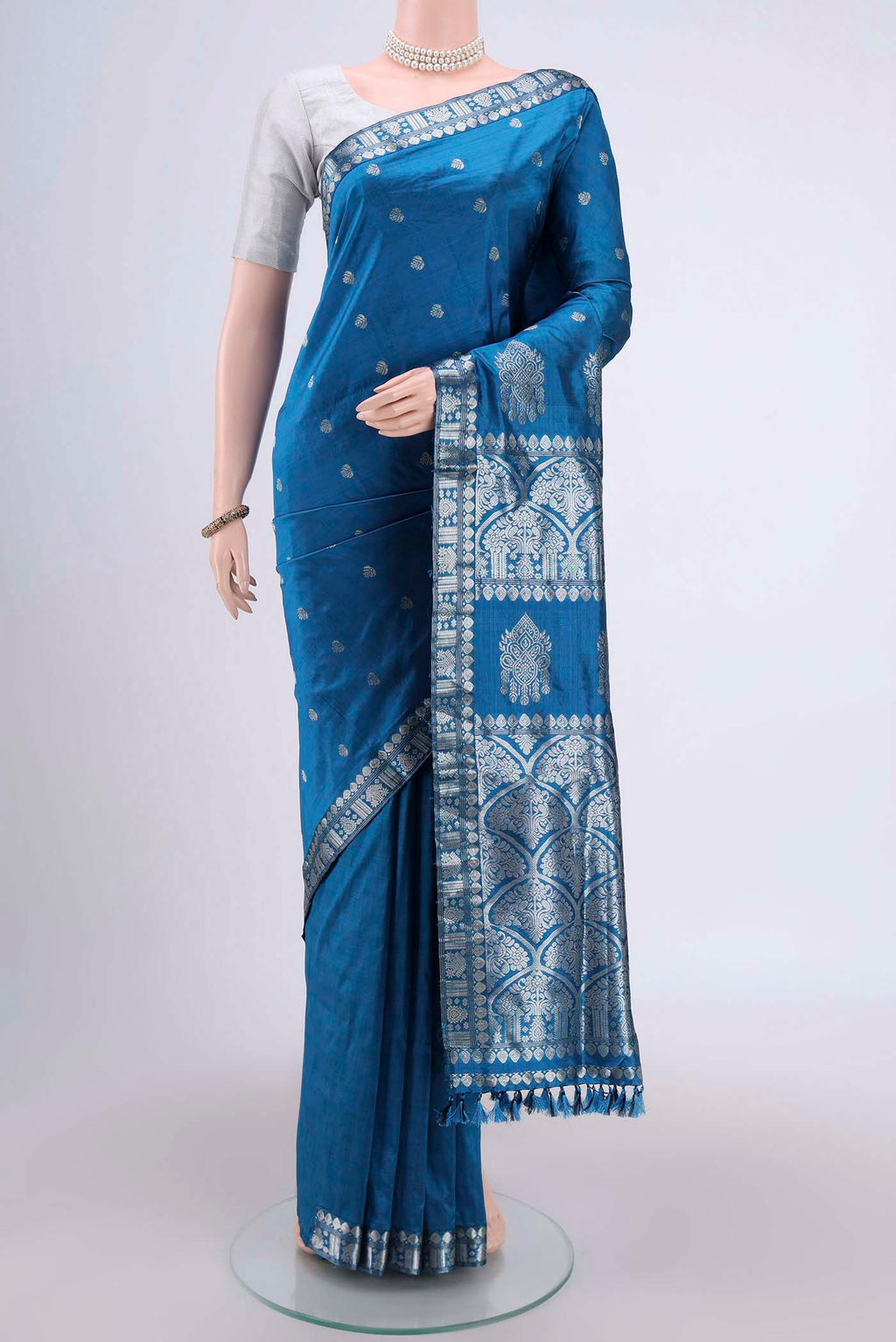 Turquoise Assam Silk Saree with Zari Butta on the body and Zari Border.  displayed on a mannequin