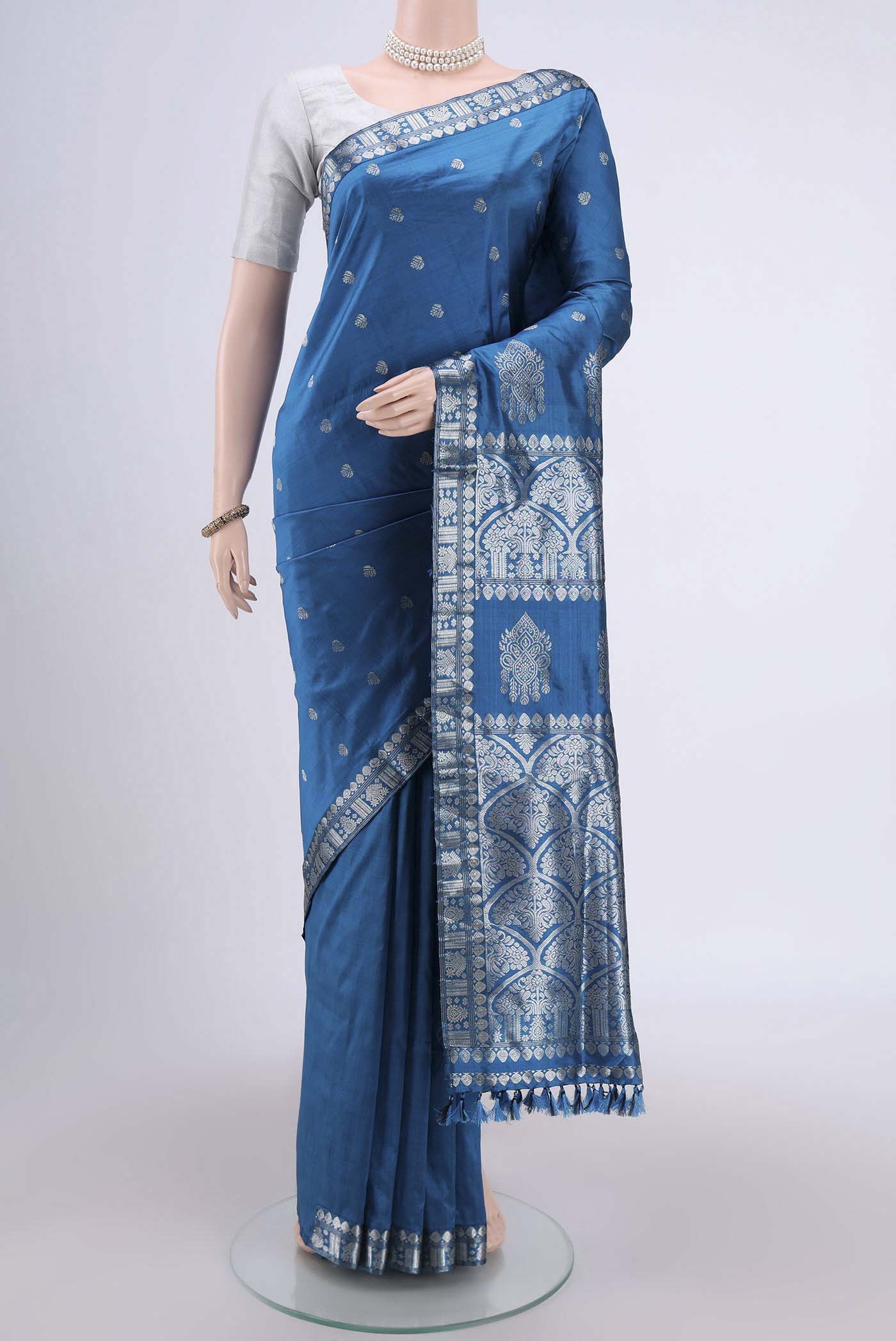 Turquoise Assam Silk Saree with Zari Butta on the body and Zari Border.  displayed on a mannequin