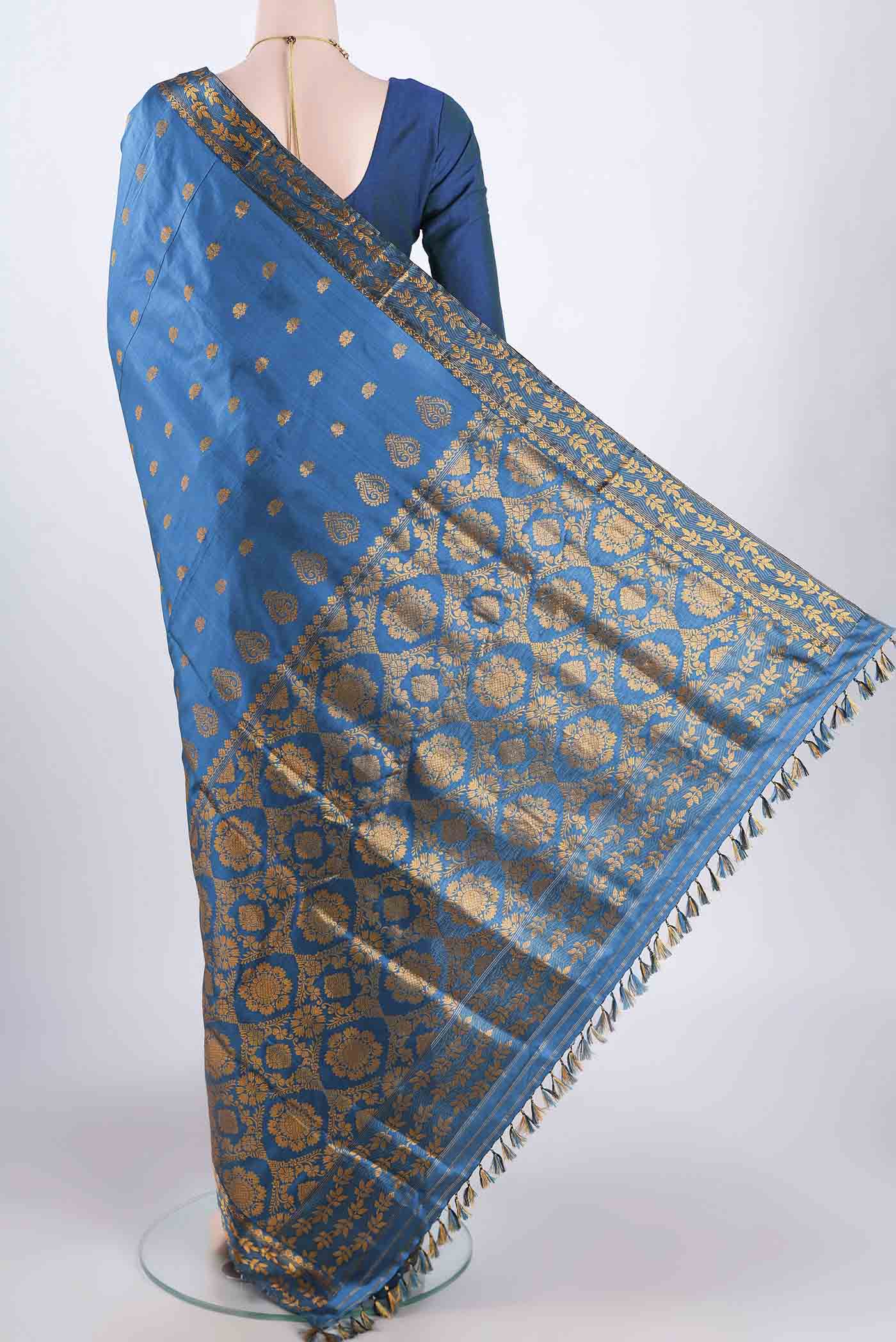 Flat view of Blue Assam Silk Saree with Zari Butta on the body and Zari Border. 
