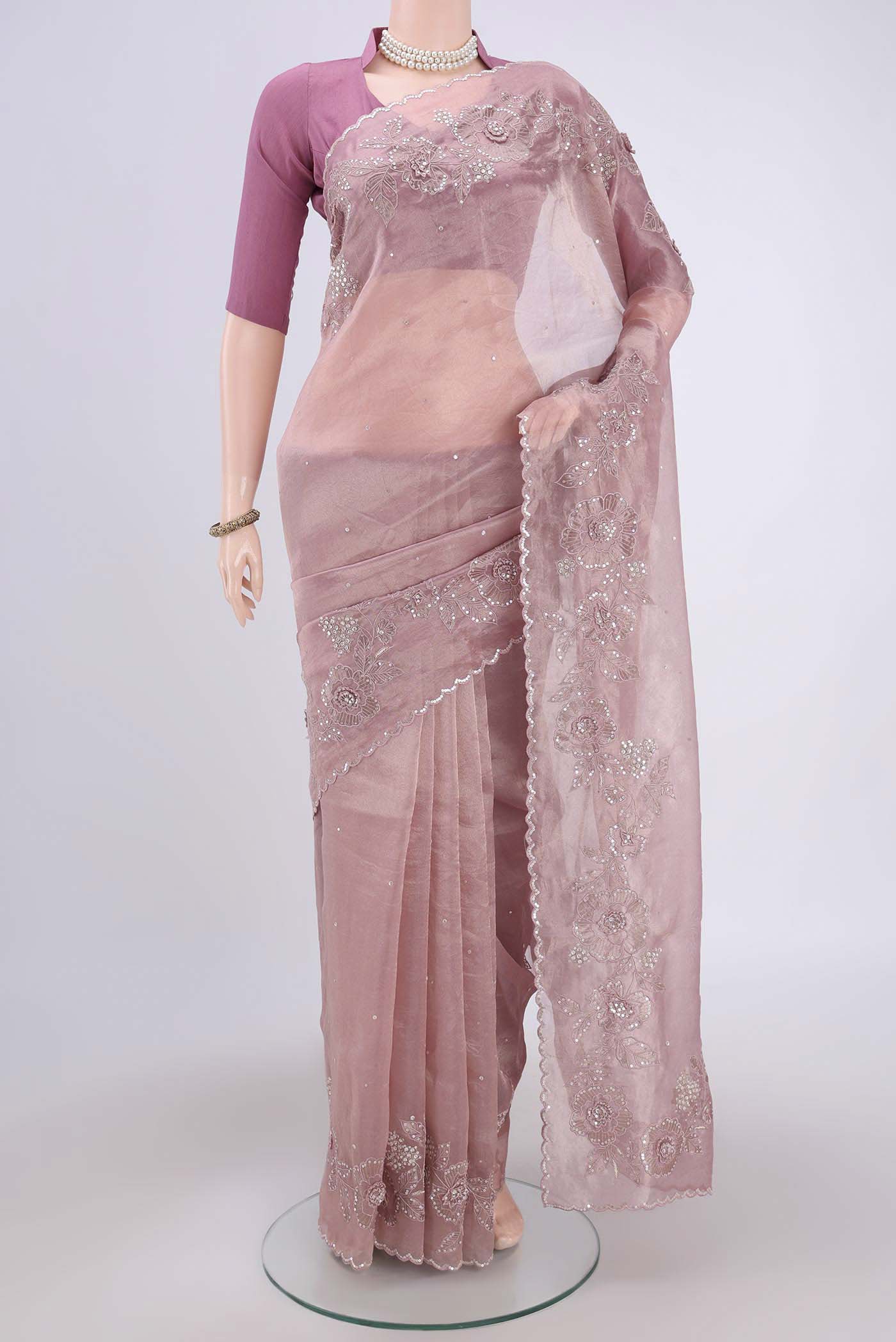 Coral Organza Silk Saree with Embroidery on the body and Embroidery Border.  displayed on a mannequin