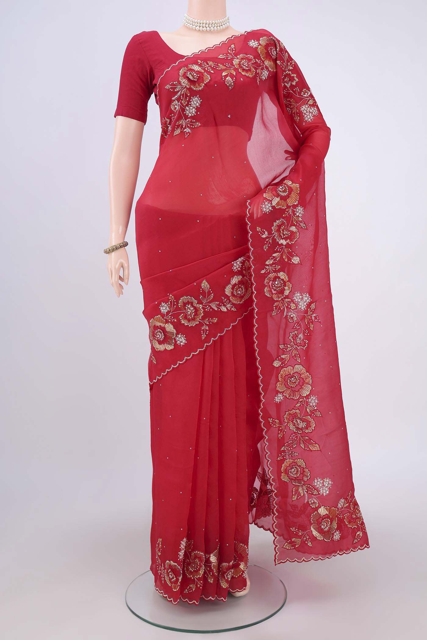 Red Organza Silk Saree with Embroidery on the body and Zari Border.  displayed on a mannequin