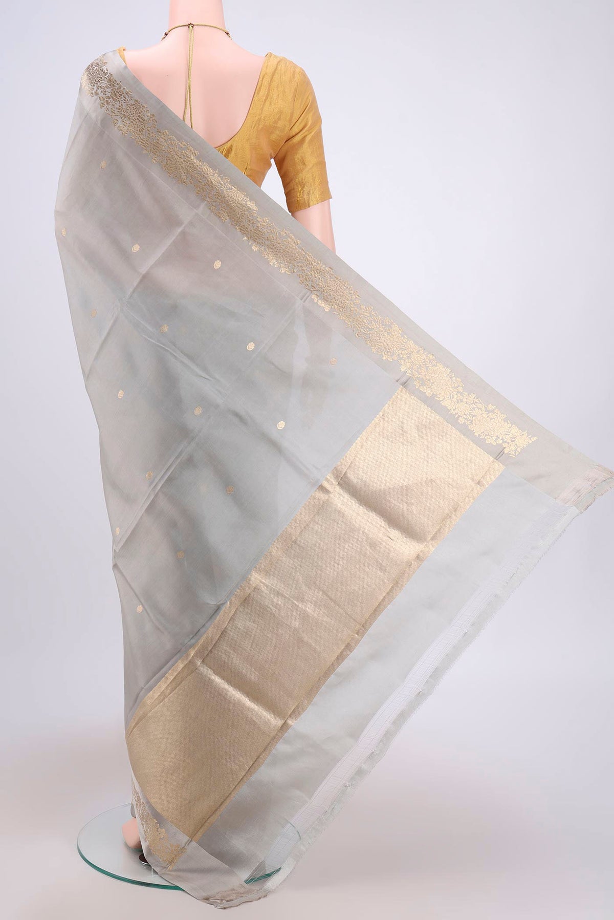 Flat view of Grey Banarasi Katan Silk Saree with Zari Butta on the body and Zari Border. 