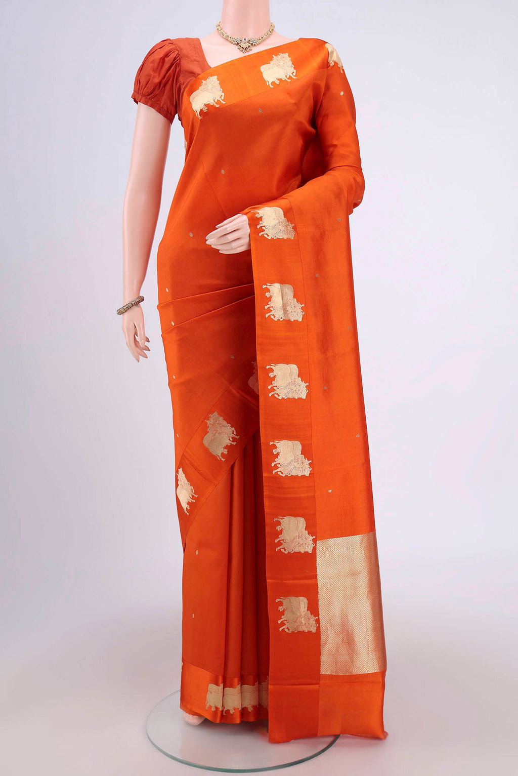 Orange Banarasi Katan Silk Saree with Zari Butta on the body and Zari Border.  displayed on a mannequin