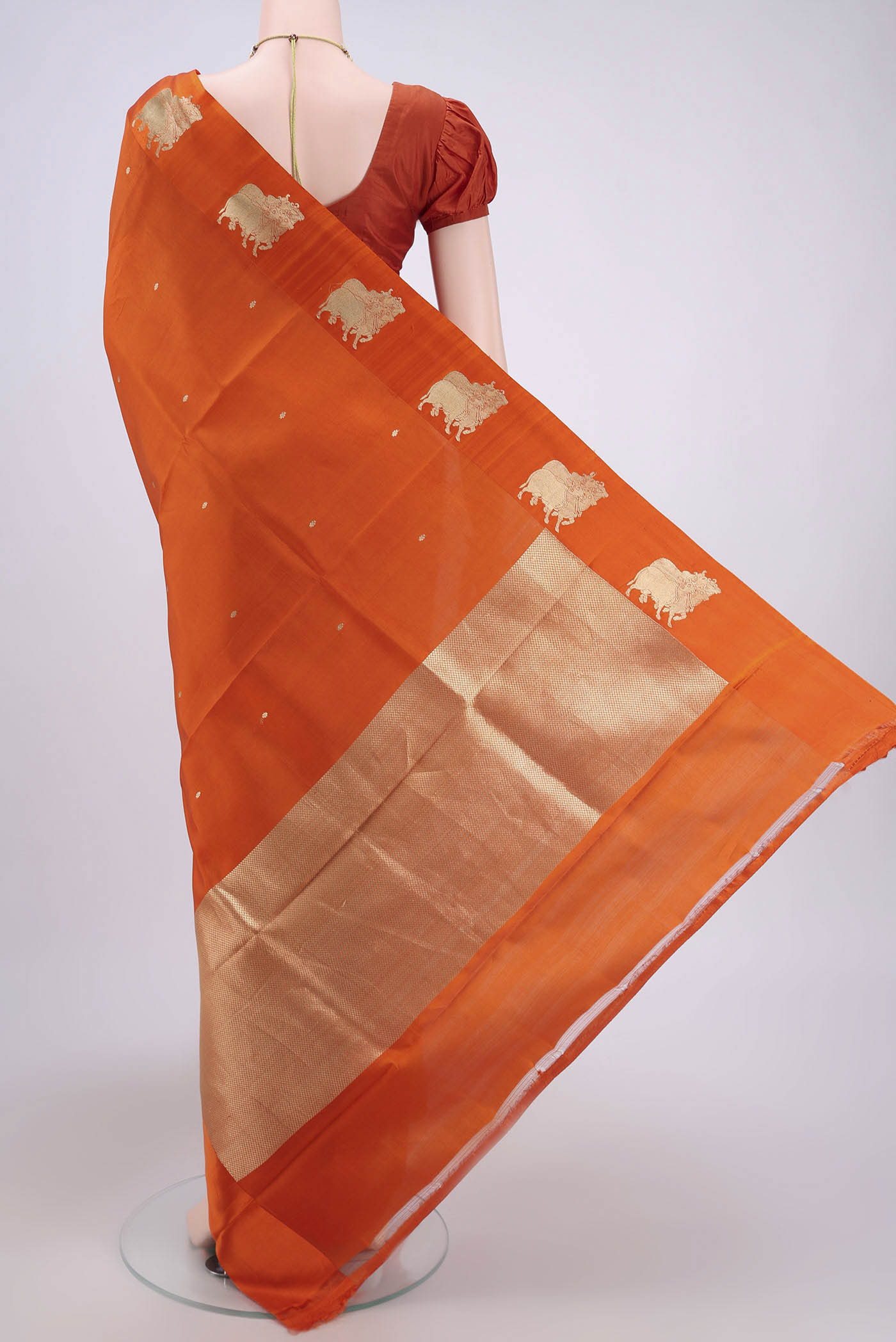 Flat view of Orange Banarasi Katan Silk Saree with Zari Butta on the body and Zari Border. 
