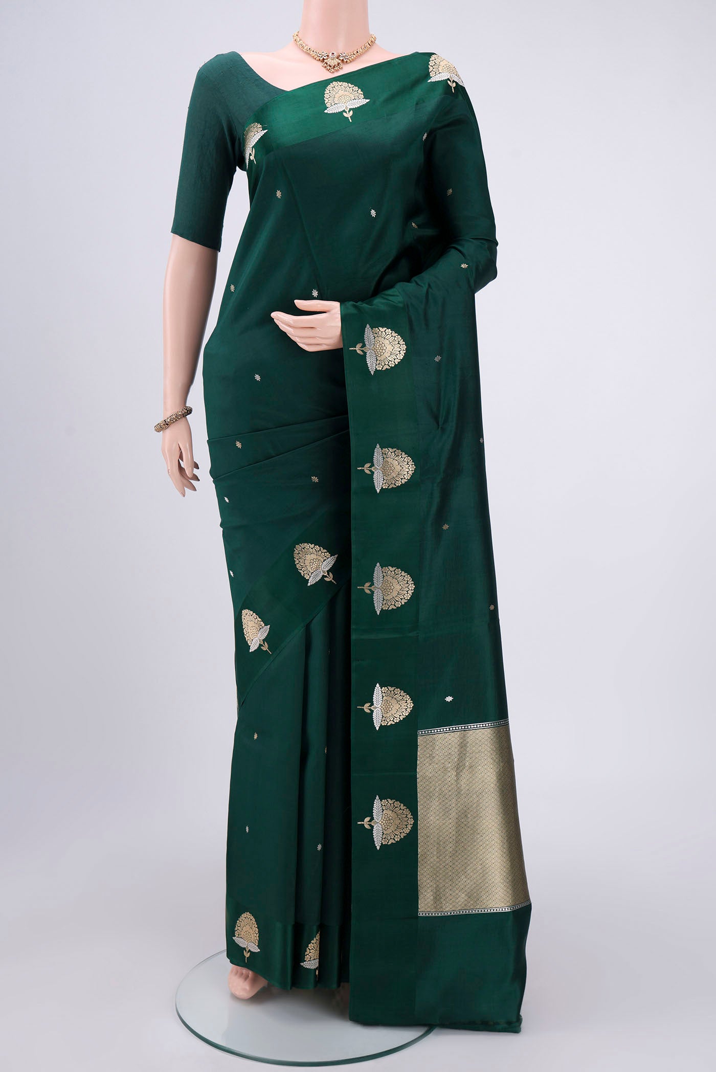 Green Banarasi Silk Saree with Zari Butta on the body and Zari Border.  displayed on a mannequin