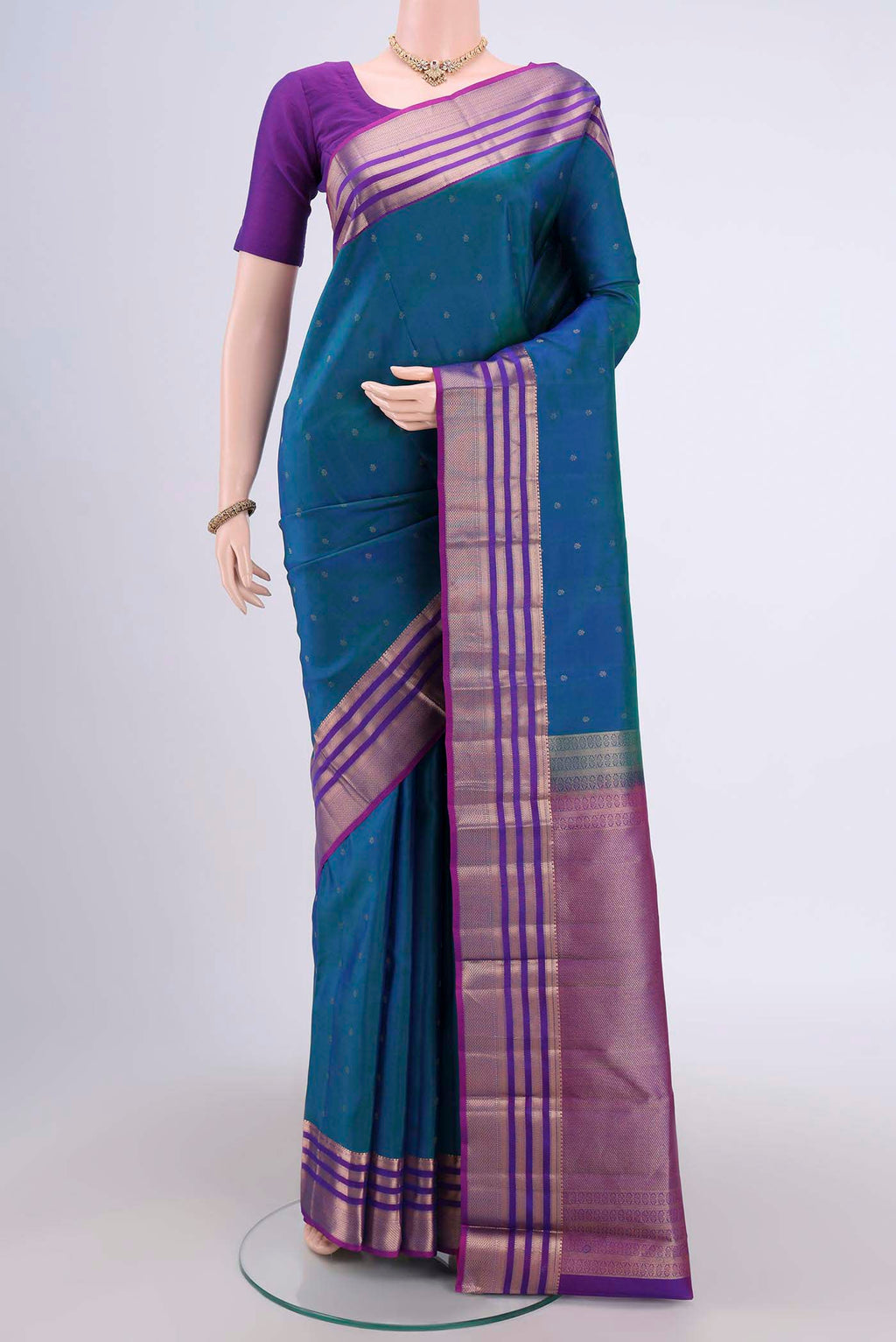 Peacock Blue Kanchipuram Saree with Zari Butta on the body and Zari Border.  displayed on a mannequin