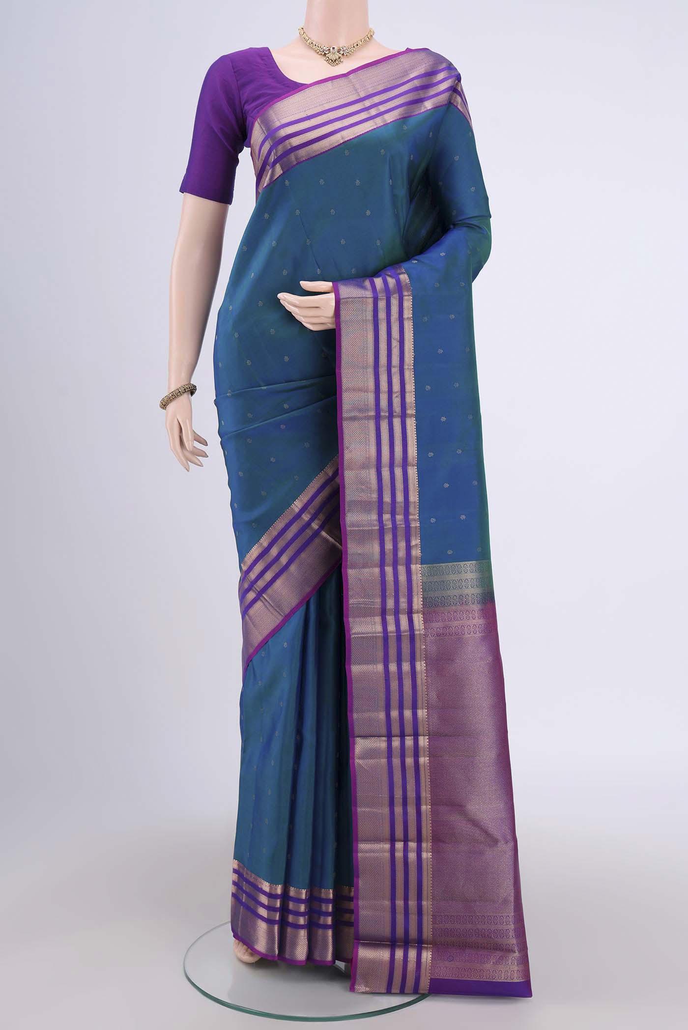 Peacock Blue Kanchipuram Saree with Zari Butta on the body and Zari Border.  displayed on a mannequin