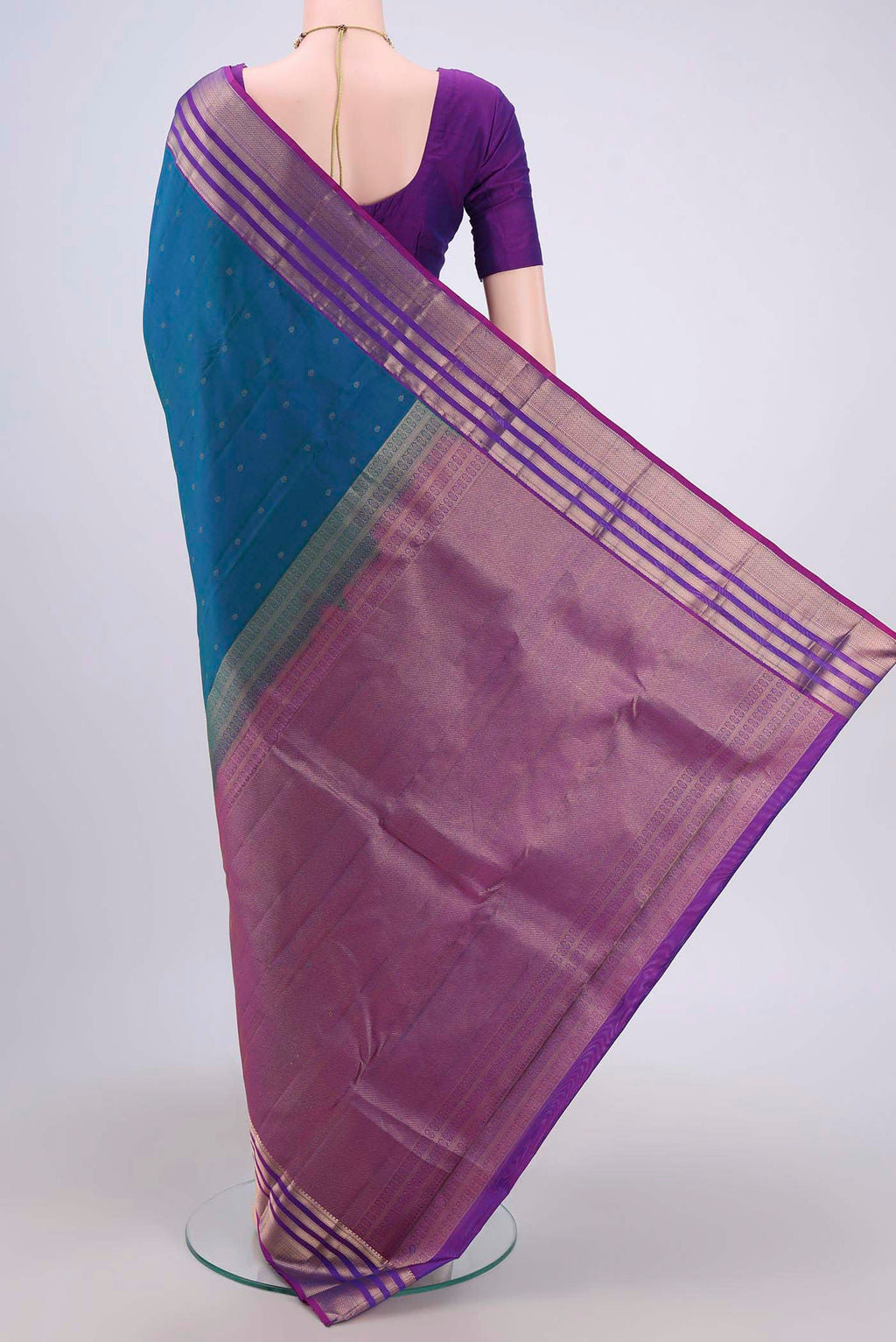 Flat view of Peacock Blue Kanchipuram Saree with Zari Butta on the body and Zari Border. 