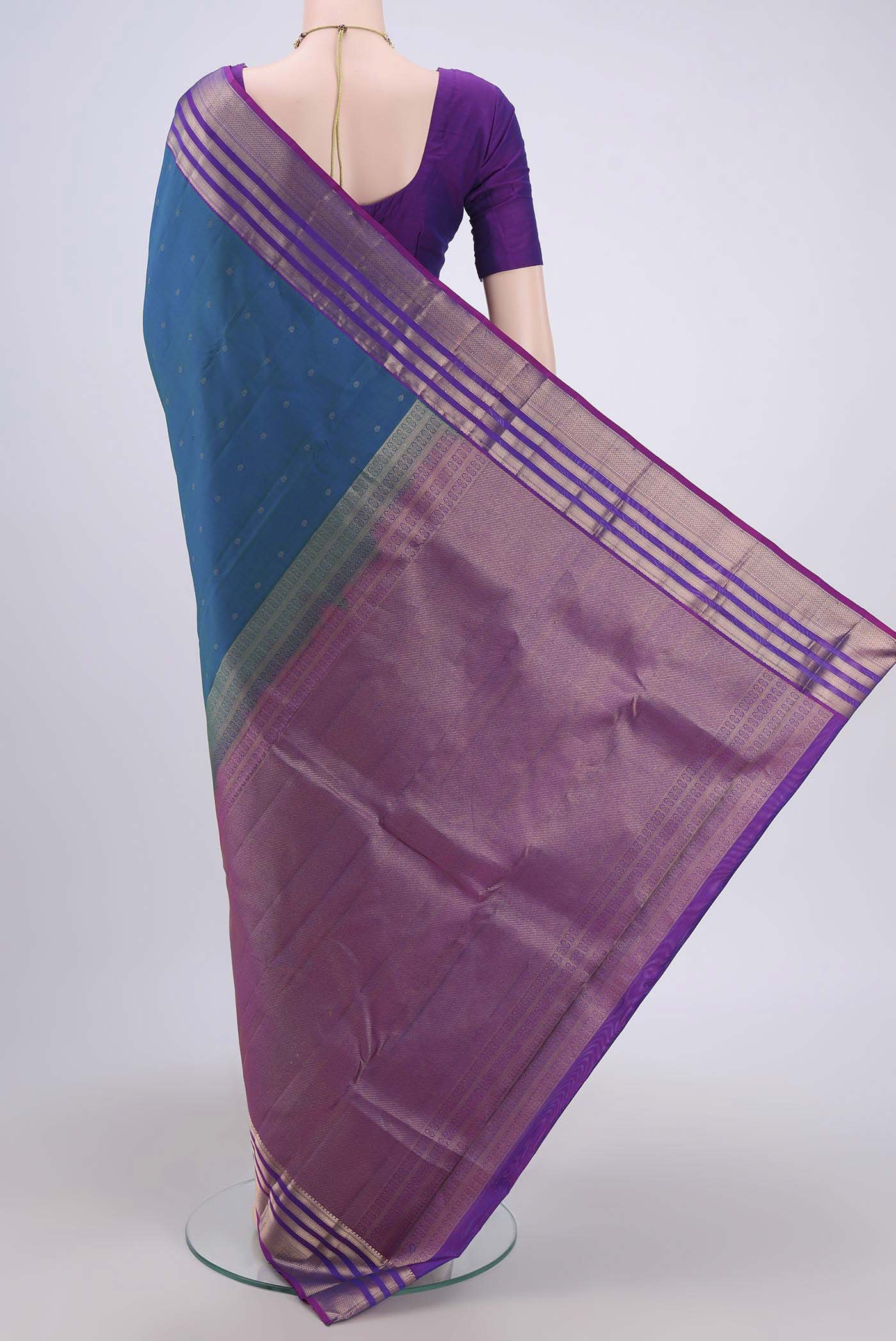 Flat view of Peacock Blue Kanchipuram Saree with Zari Butta on the body and Zari Border. 