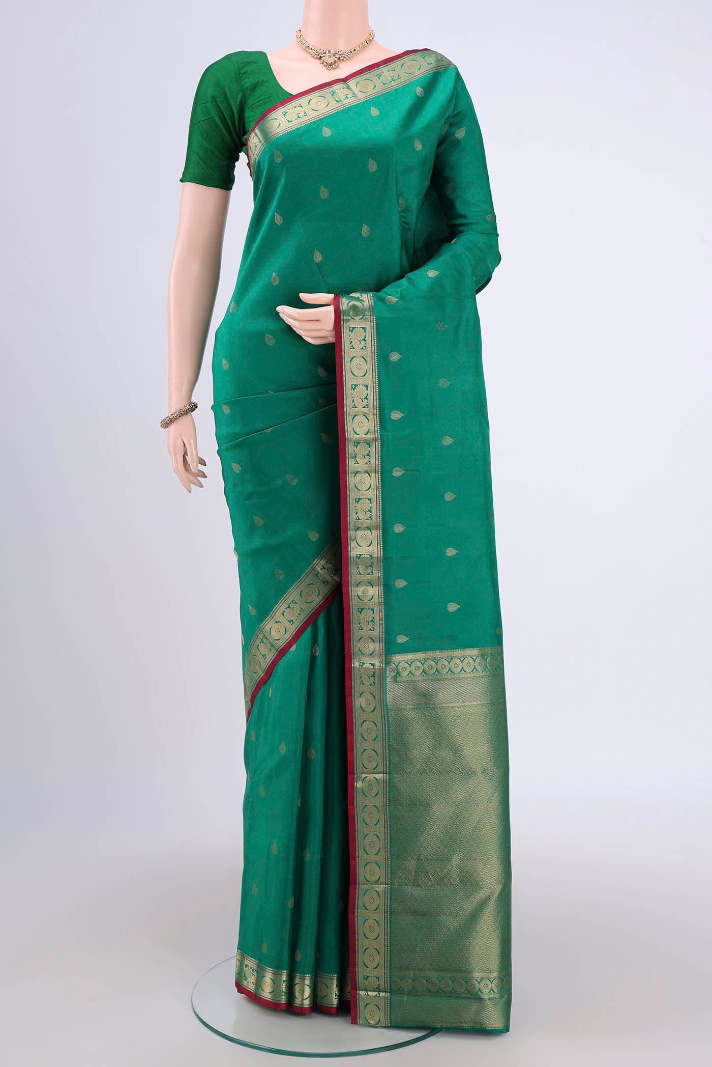 Green Dual Tone Kanchipuram Saree with Zari Butta on the body and Zari Border.  displayed on a mannequin