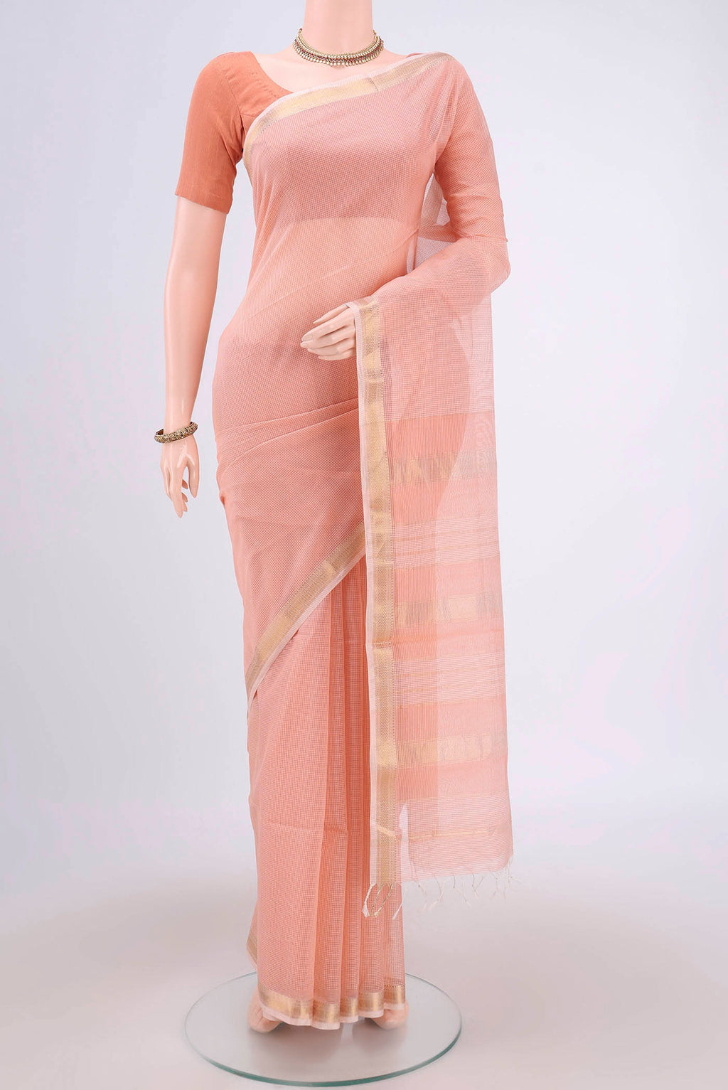 Peach Maheshwari Silk Cotton Saree with Plain Body and Zari Border.  displayed on a mannequin