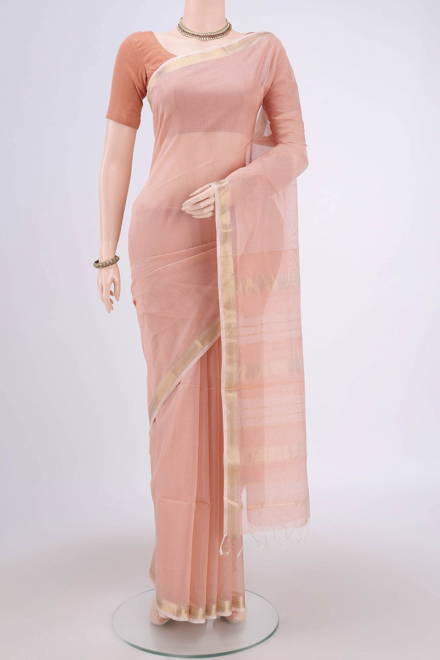 Peach Maheshwari Silk Cotton Saree with Plain Body and Zari Border.  displayed on a mannequin