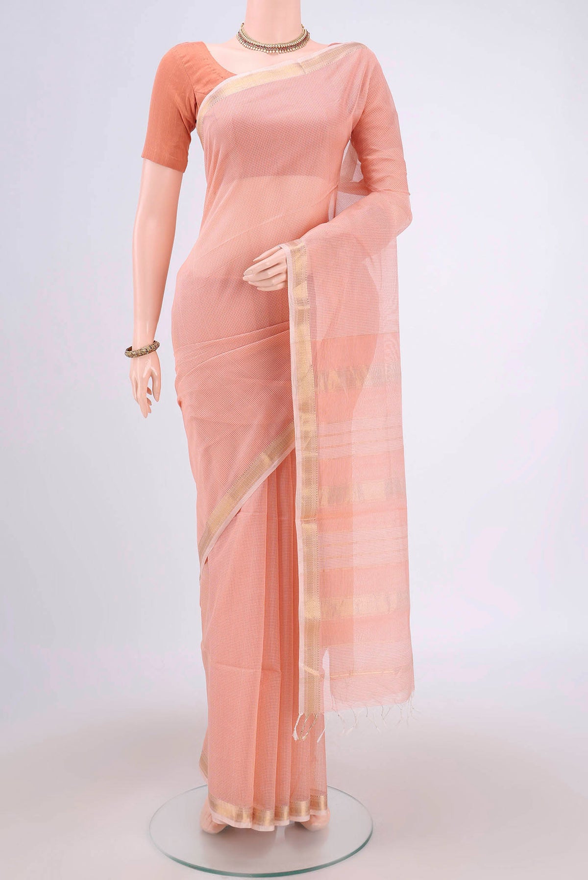 Peach Maheshwari Silk Cotton Saree with Plain Body and Zari Border.  displayed on a mannequin