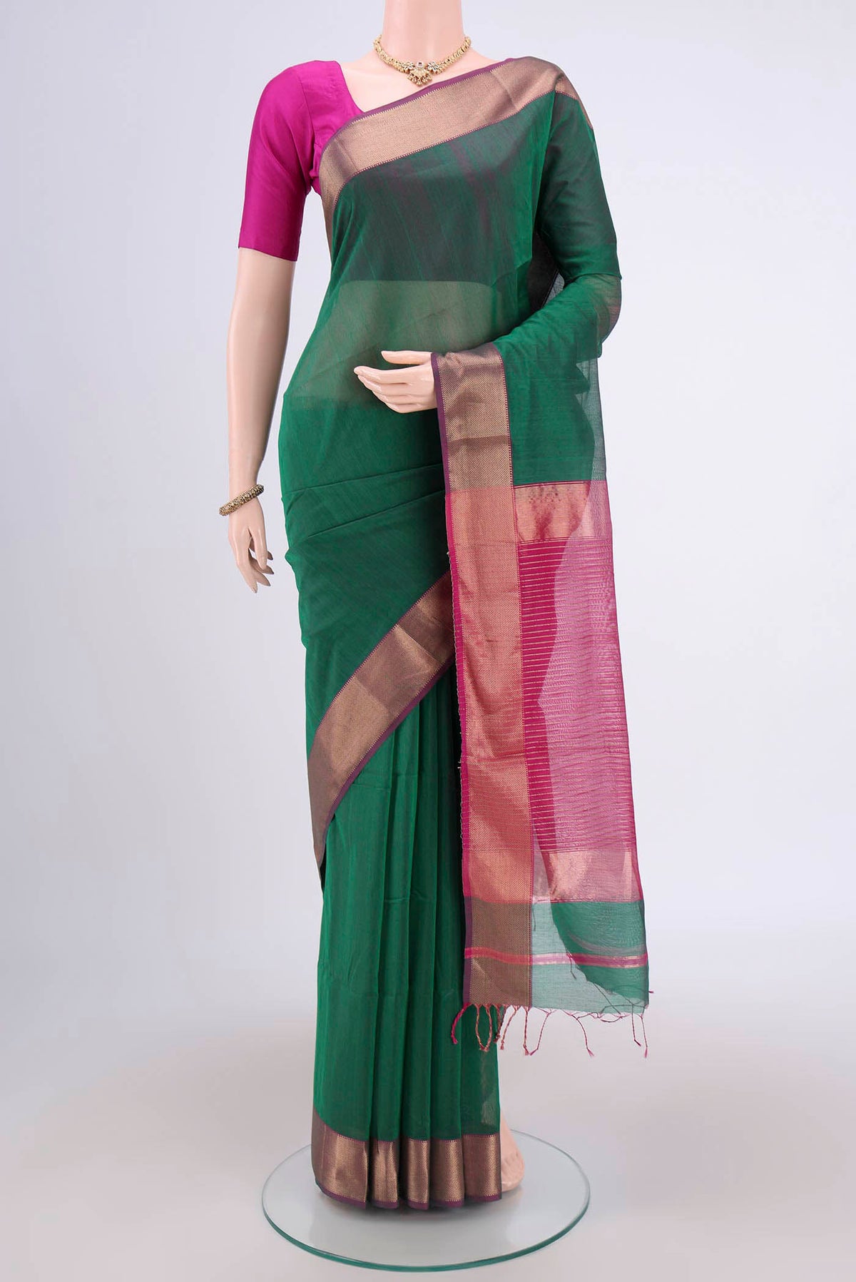 Bottle Green Maheshwari Silk Cotton Saree with Zari And Thread Butta on the body and Zari Border.  displayed on a mannequin