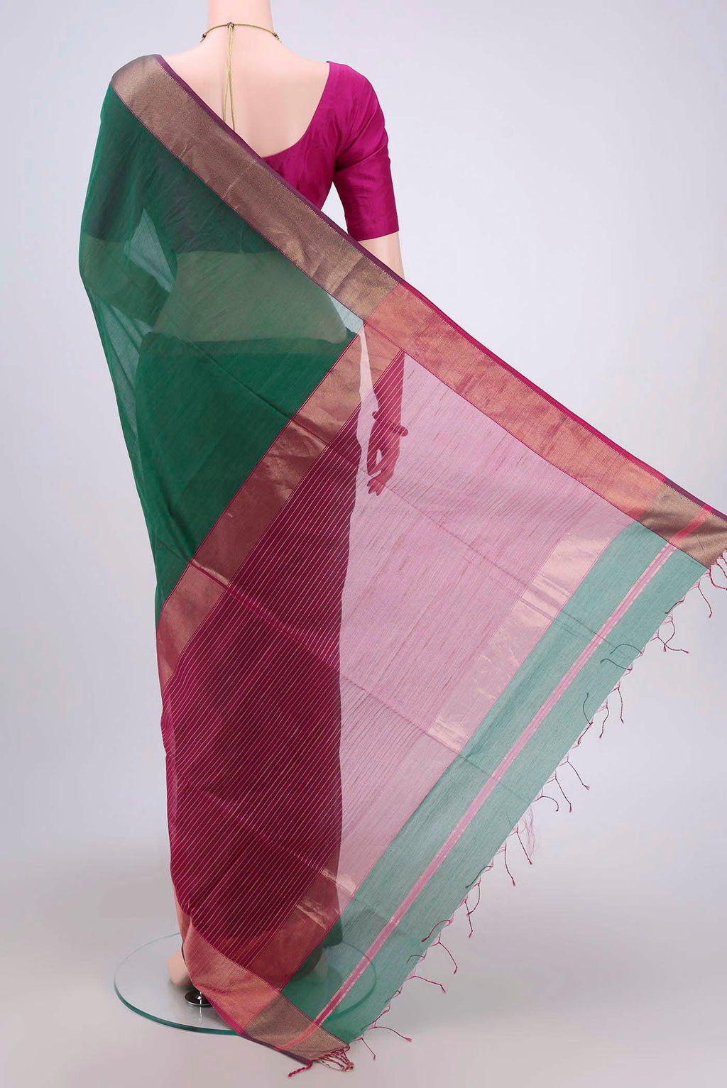 Flat view of Bottle Green Maheshwari Silk Cotton Saree with Zari And Thread Butta on the body and Zari Border. 